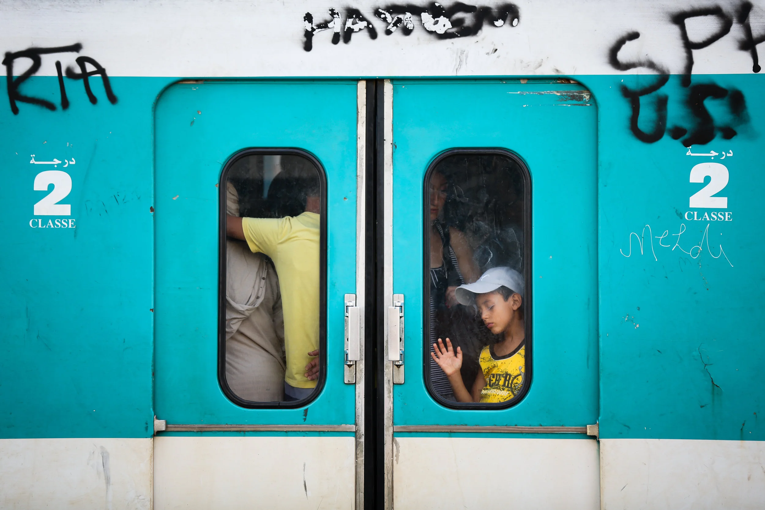 A boy is seen through the doors of a commuter rail train car in Tunis, Tunisia
