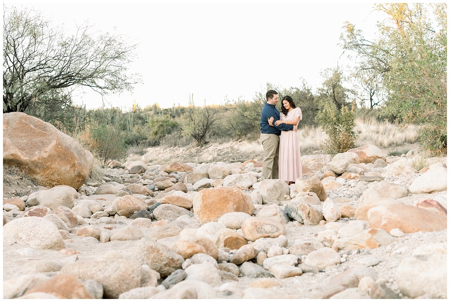 Catalina State Park Engagement Session with couple standing in the distance surrounded by sandy white boulders.
