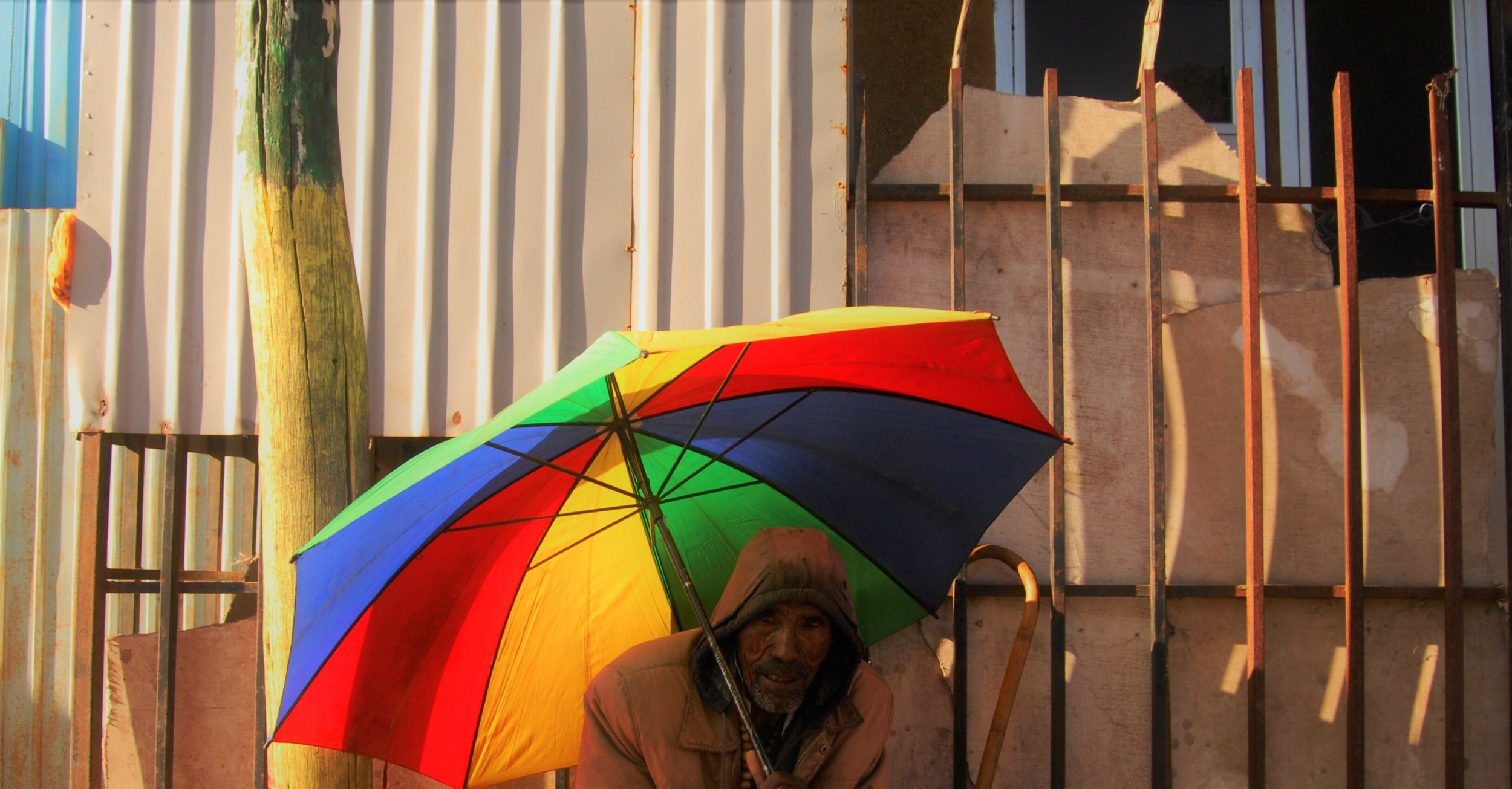 10. A photo of an senior man holding a colorful umbrella. 