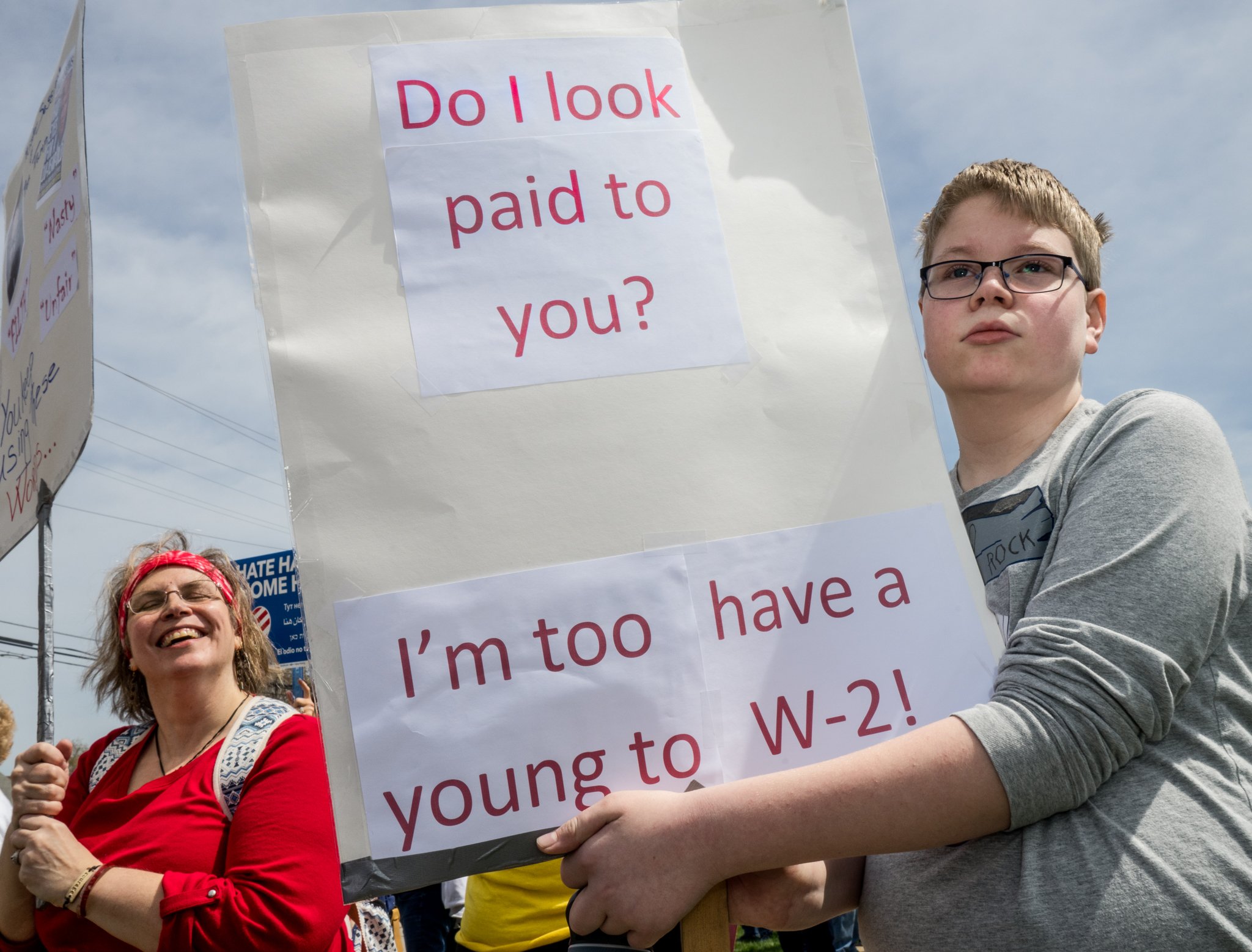 Boy holding sign that references that he is not a paid&nbsp;protester