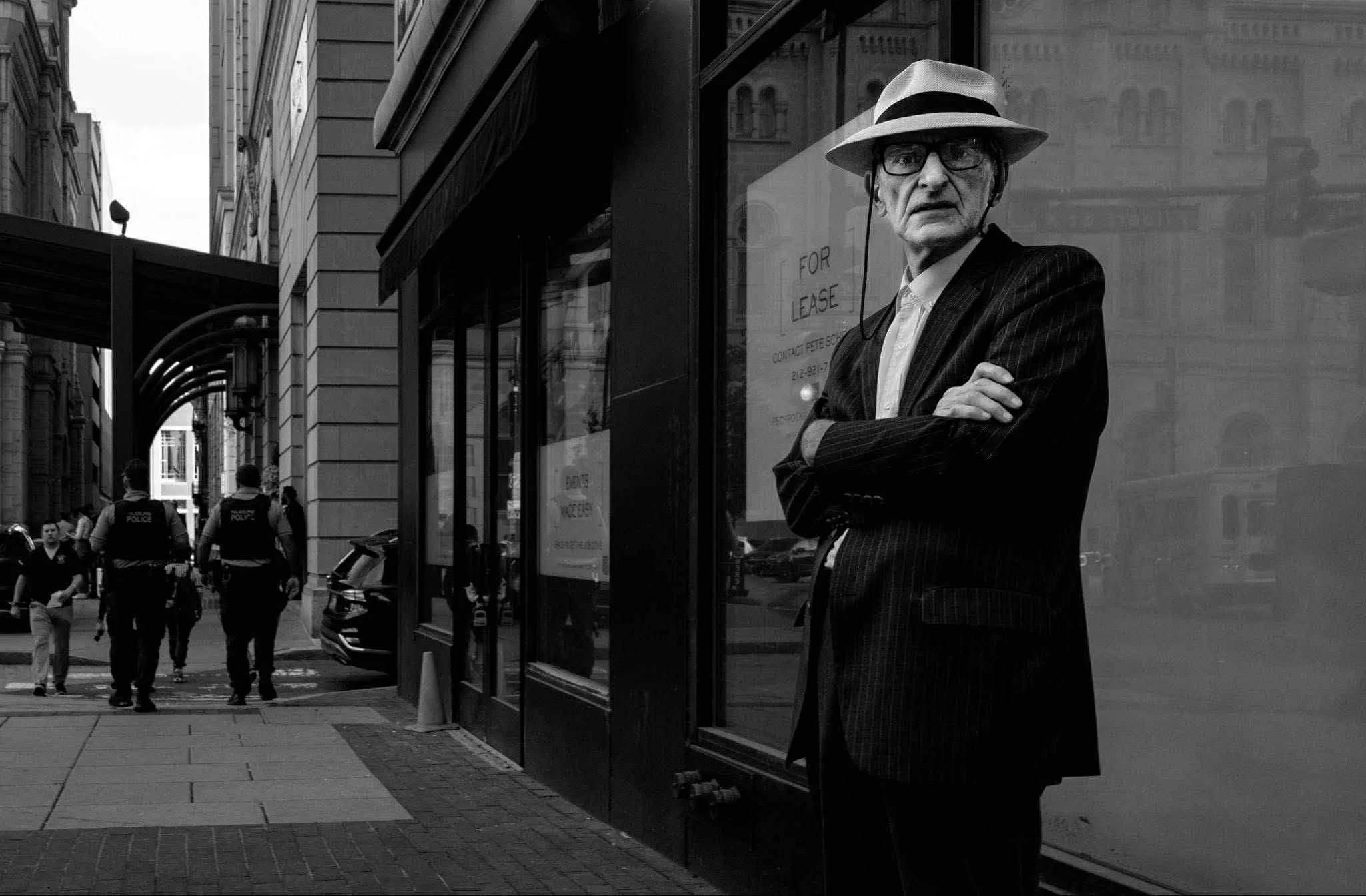 Barbara Craig. You can interpret this scene as either the protagonist reacting to the photographer or sharing feelings about two policemen on the sidewalk. Either way, it’s a poignant street portrait.