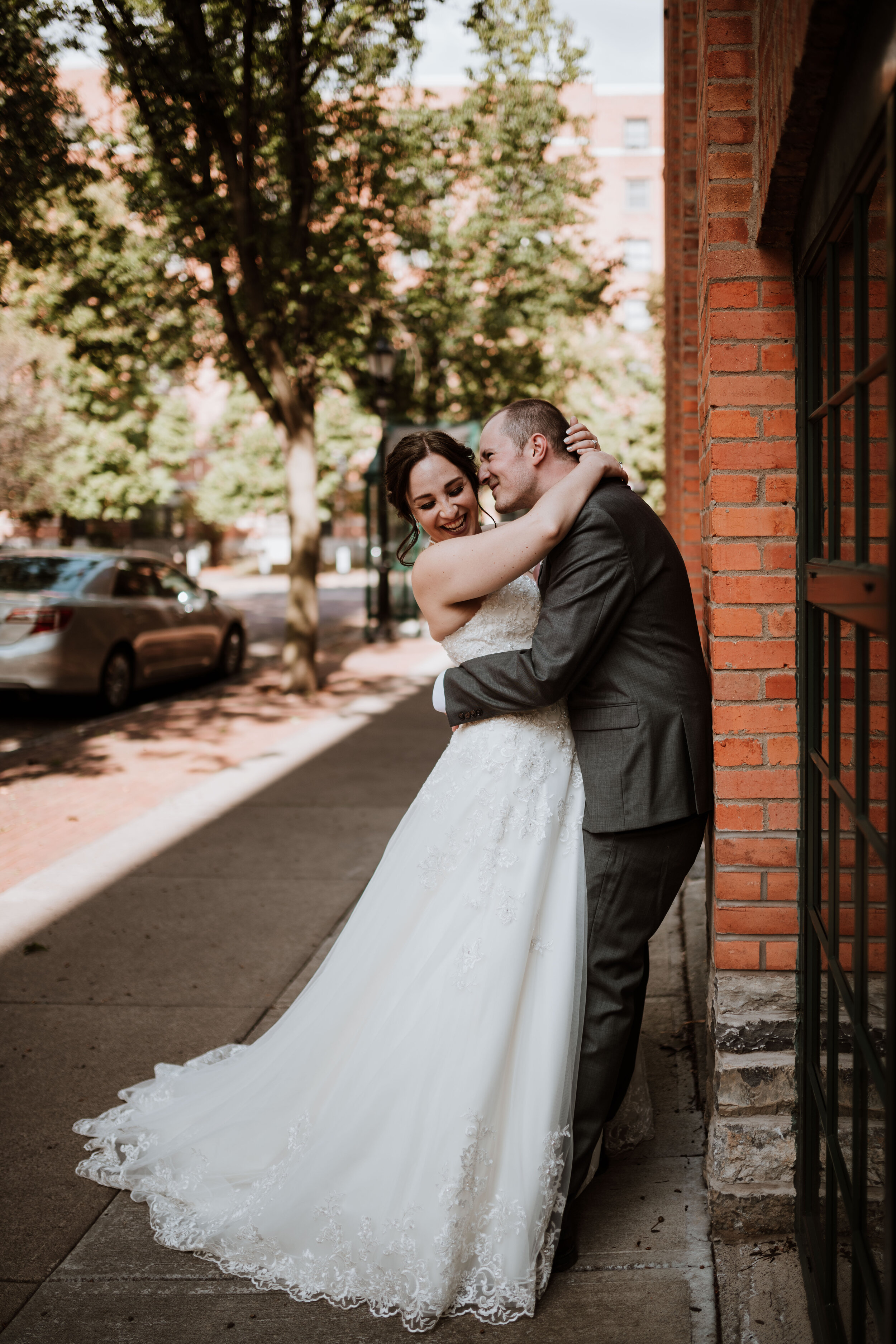 Newlywed couple embracing in a playful manner at their wedding in Syracuse, New York.