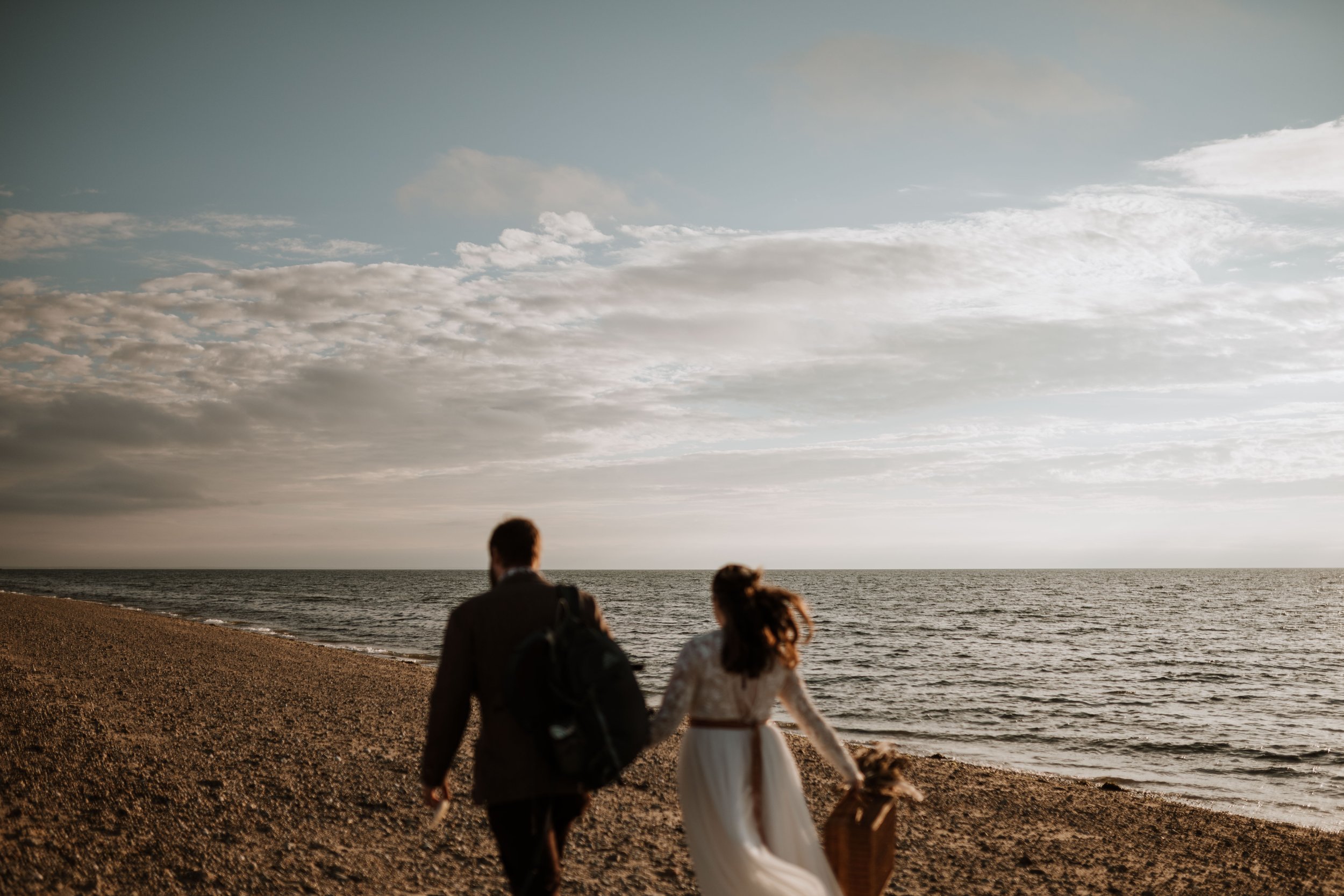 Couple walking together with the ocean in focus.