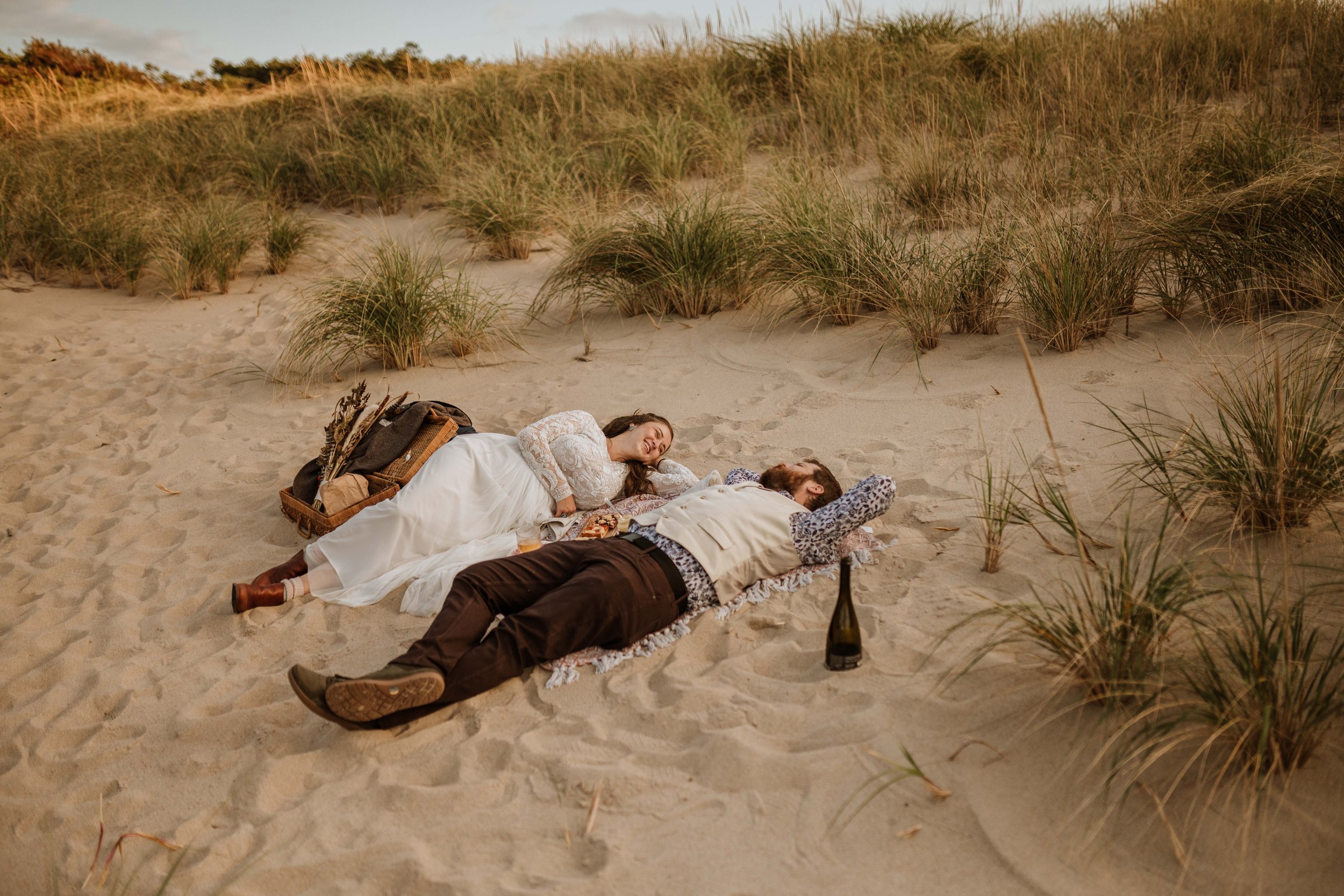 Couple lying together in the sand.