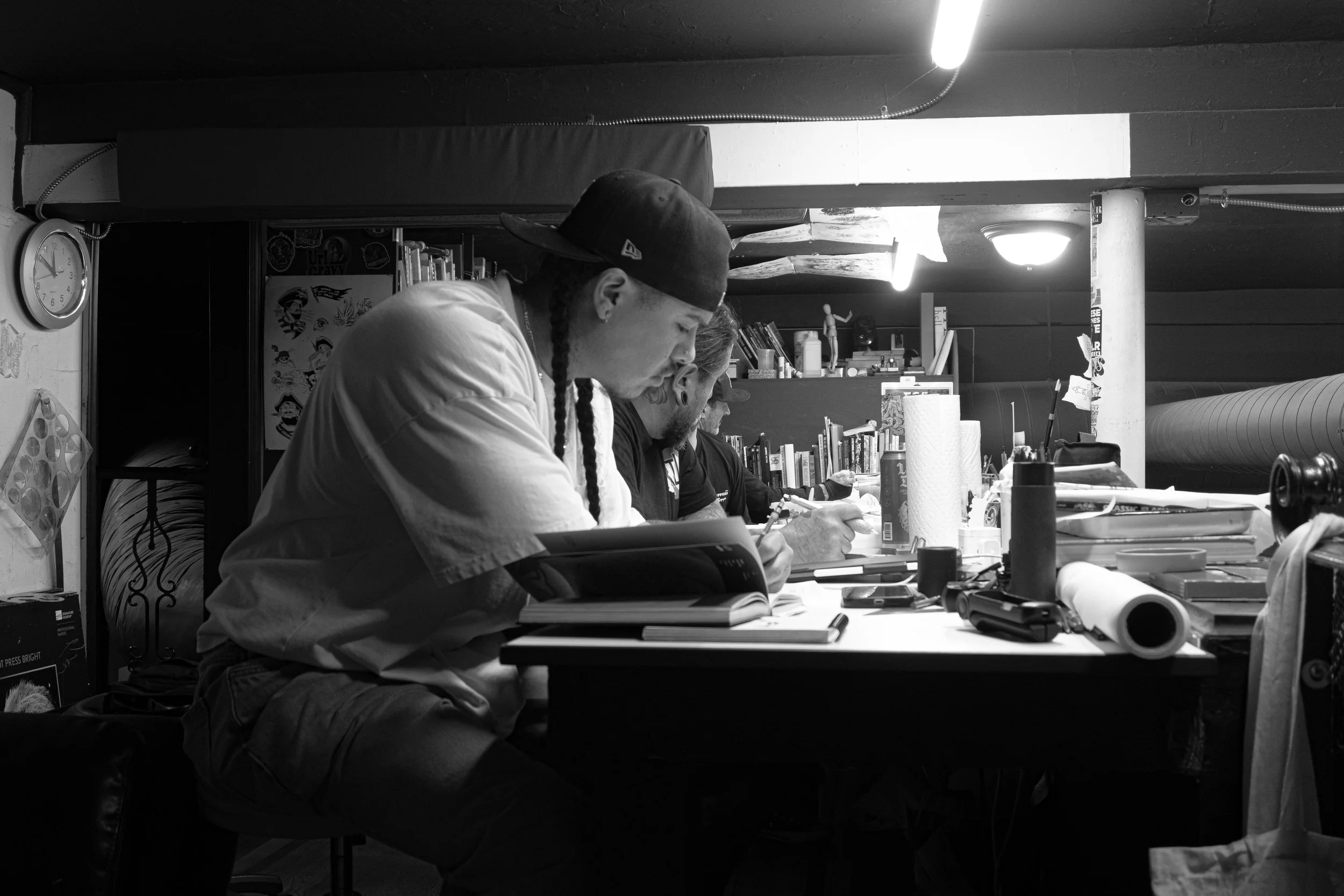 Denver Mexican artist Arturo working on fine line Chicano black and grey tattoos