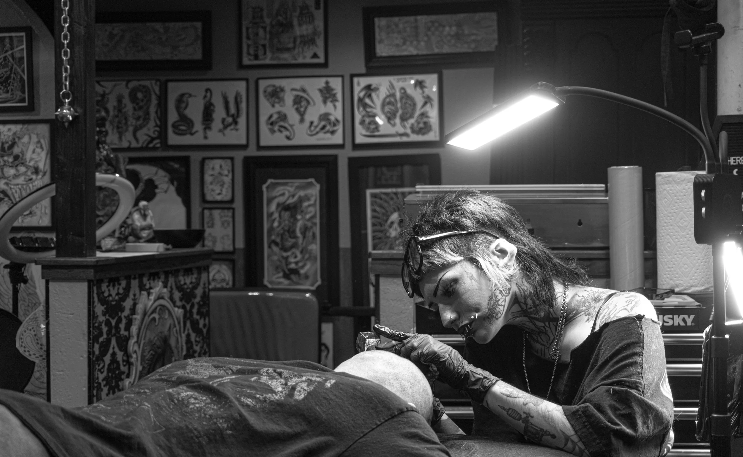 Blackwork tattoo artist Jas tattooing a gothic design head piece