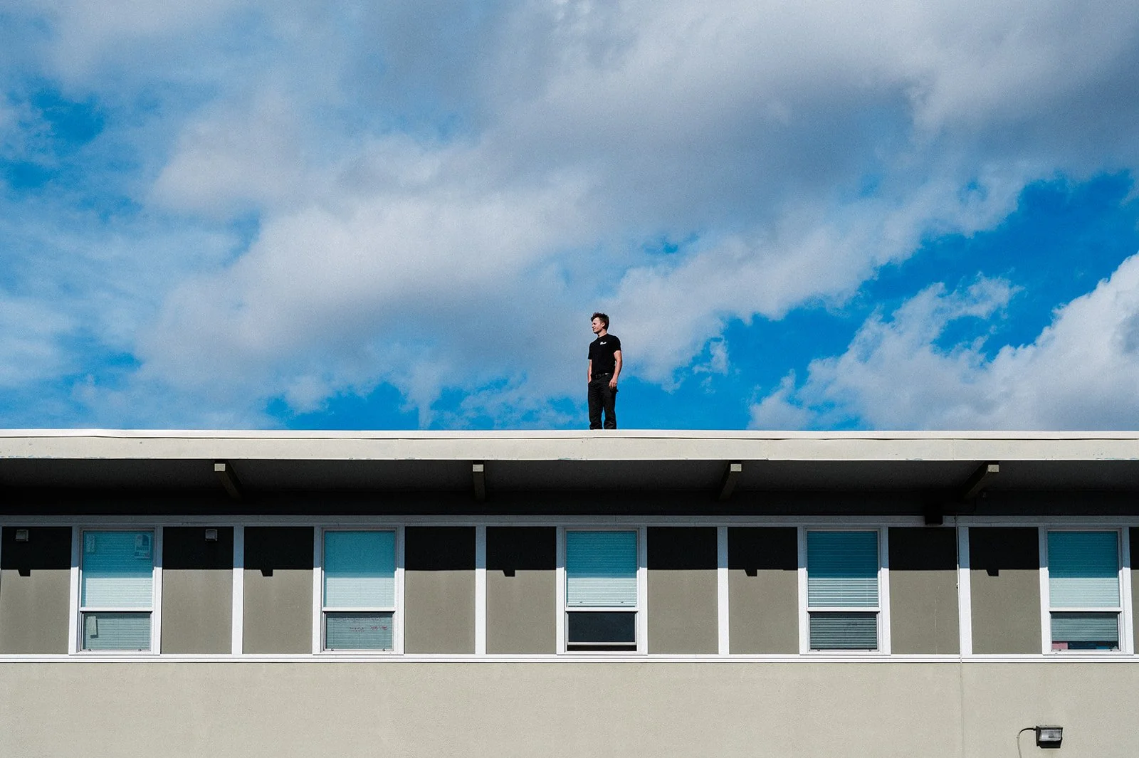 Maxwell Mechanical team member standing on the roof of a commercial building in Kamloops during a rooftop HVAC service visit.