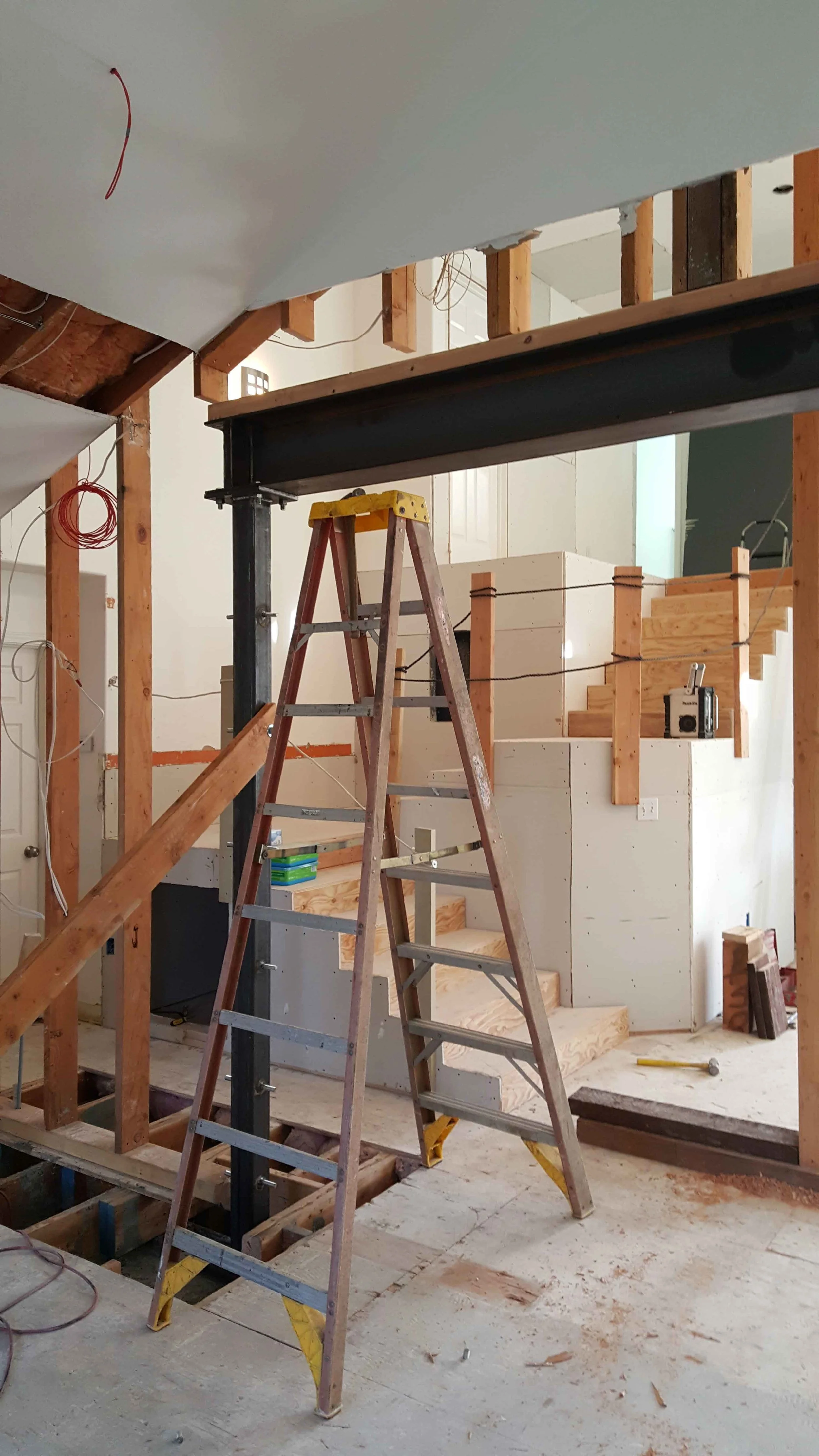 Removing an interior bearing wall and installing a new exposed steel beam.