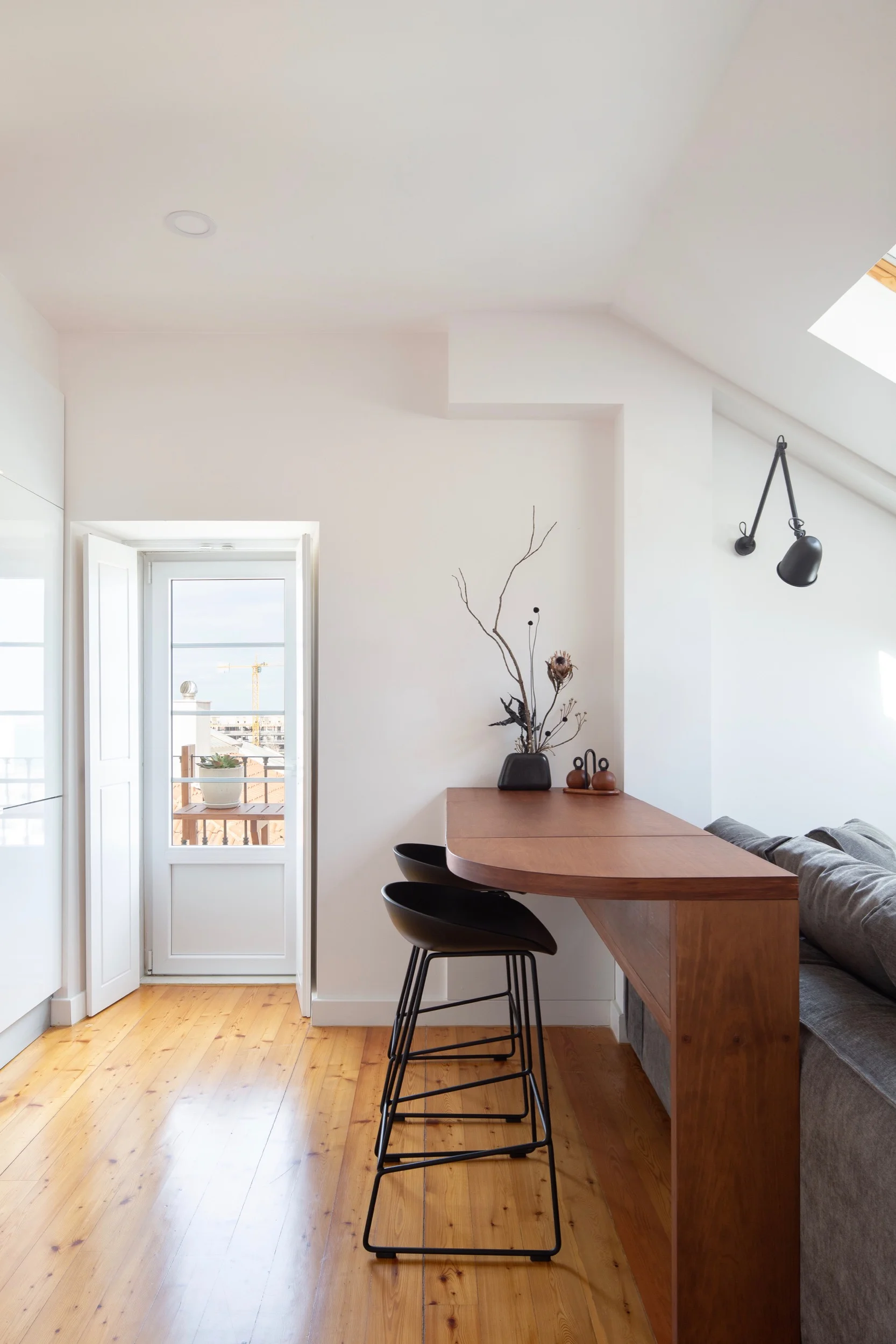 Photo of Lola Cwikowski Studio Travessa da Pereira Apartment residential project showing sofa, custom millwork breakfast bar, and HAY About a Stool.