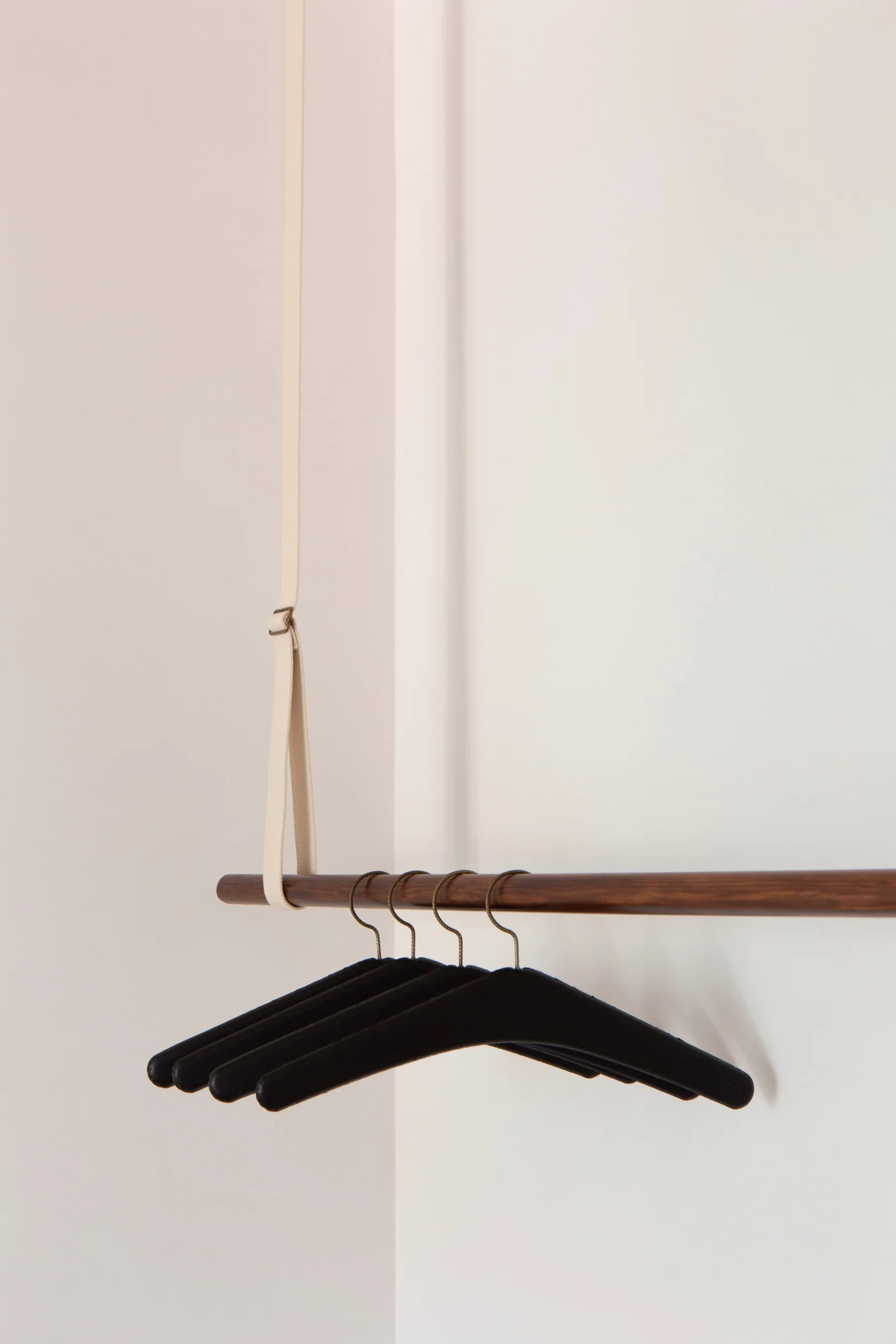 Detail photo of Lola Cwikowski Studio Travessa da Pereira Apartment residential project showing bedroom custom hanging system with vintage black leather hangers.