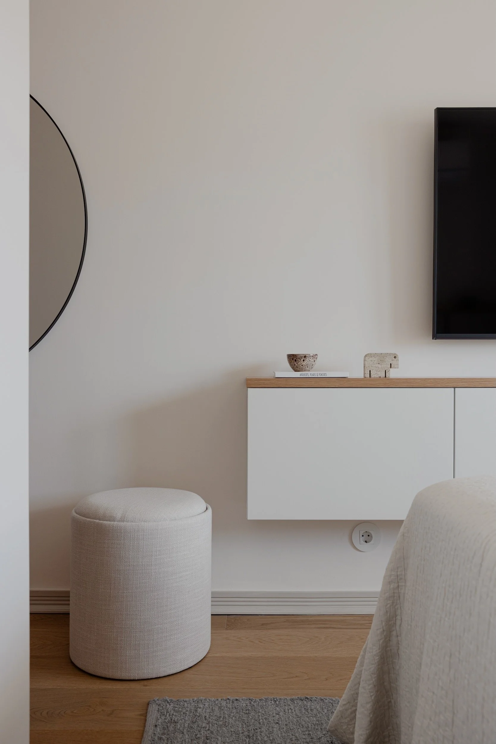Lola Cwikowski Studio Cascais Residence project with custom oak top panel on IKEA Bestå console; LG TV; upholstered ottoman; Zara Home round mirror; Apricots, Pears & Peaches, Florin Gheorghiu.