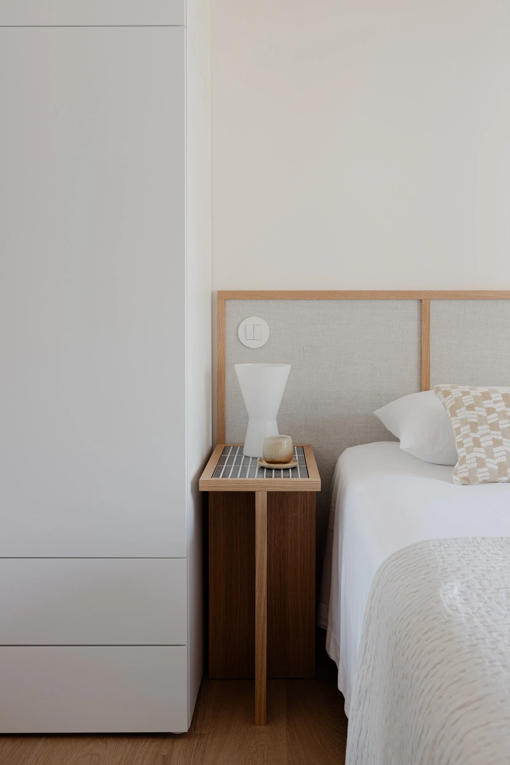 Lola Cwikowski Studio Cascais Residence project with custom Somma Carpintaria oak & linen headboard; nightstand with Marokk Kayo Tokyo tile top; IKEA Platsa wardrobe; Larsen Tomas pillow; vintage ceramic vase.