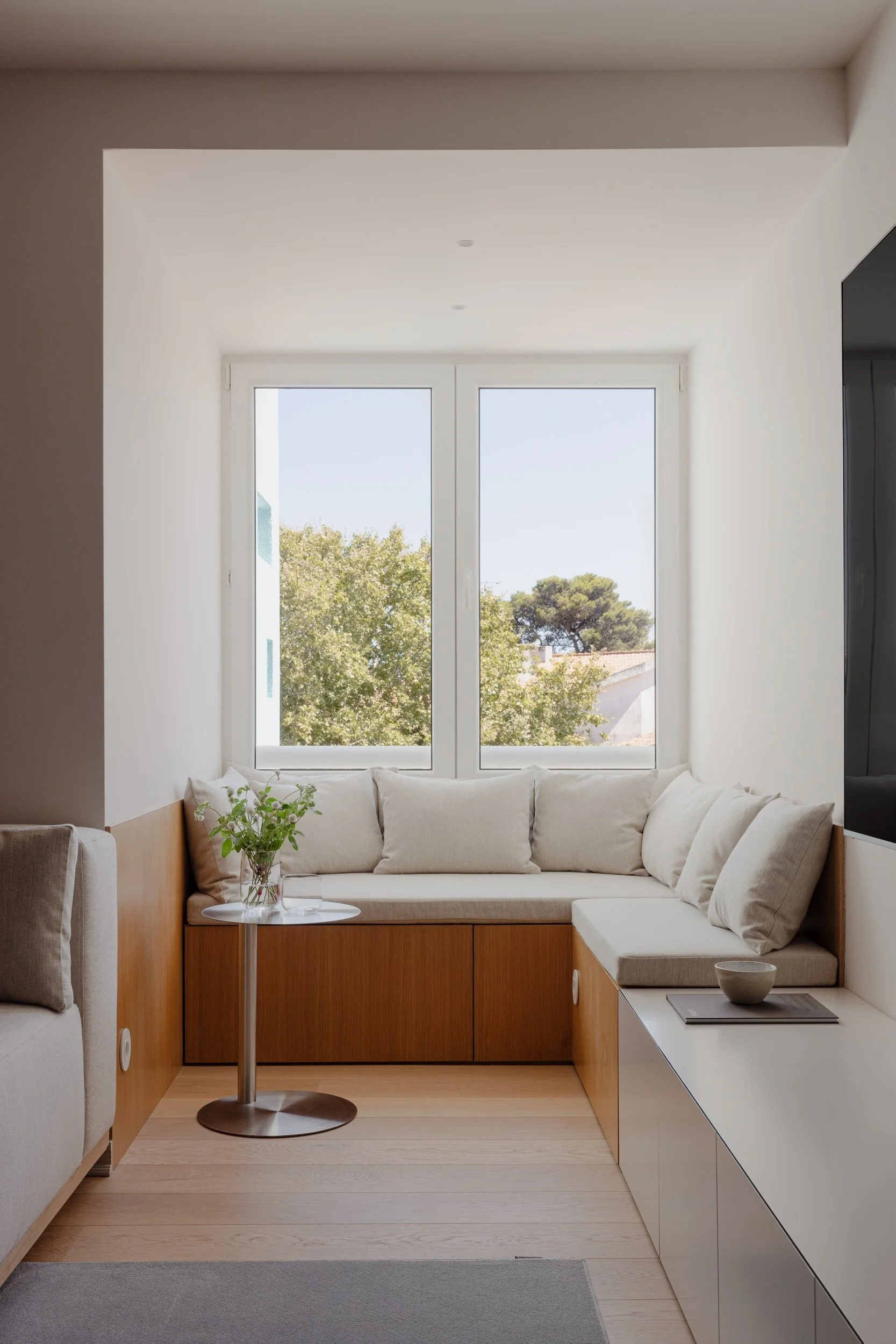 Lola Cwikowski Studio Cascais Residence project with custom oak window bench with Maria Menino cushions in Lauritzon Aqua; Francisco Segarra Sirka side table; custom media unit; CutCut Praia rug; Fenesteves engineered oak floor.