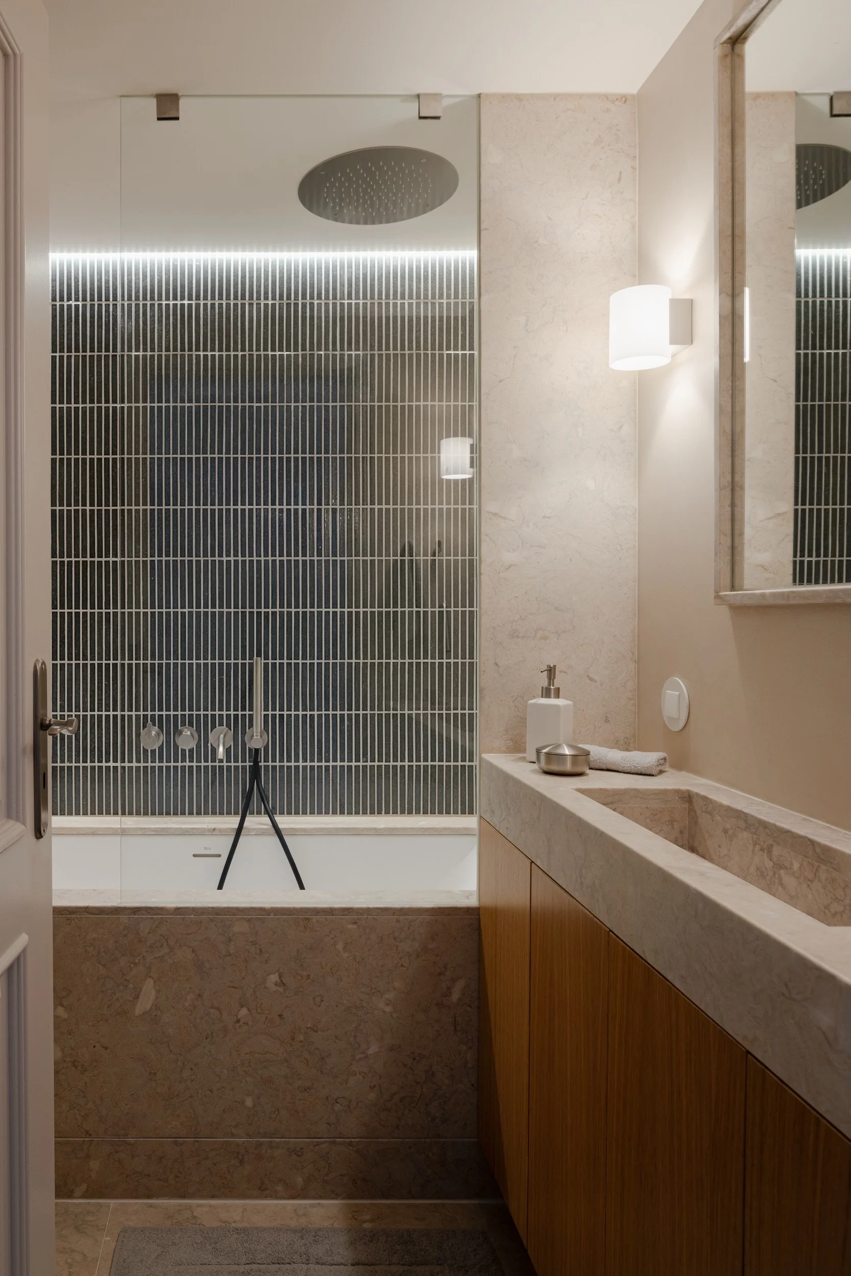 Lola Cwikowski Studio Cascais Residence project with custom Lioz bathtub surround, countertop & integrated sink; oak vanity; Bruma X-Alpha fixtures; Marokk Kayo Tokyo tile; Herstal Evoke sconce; Brilumen LED.