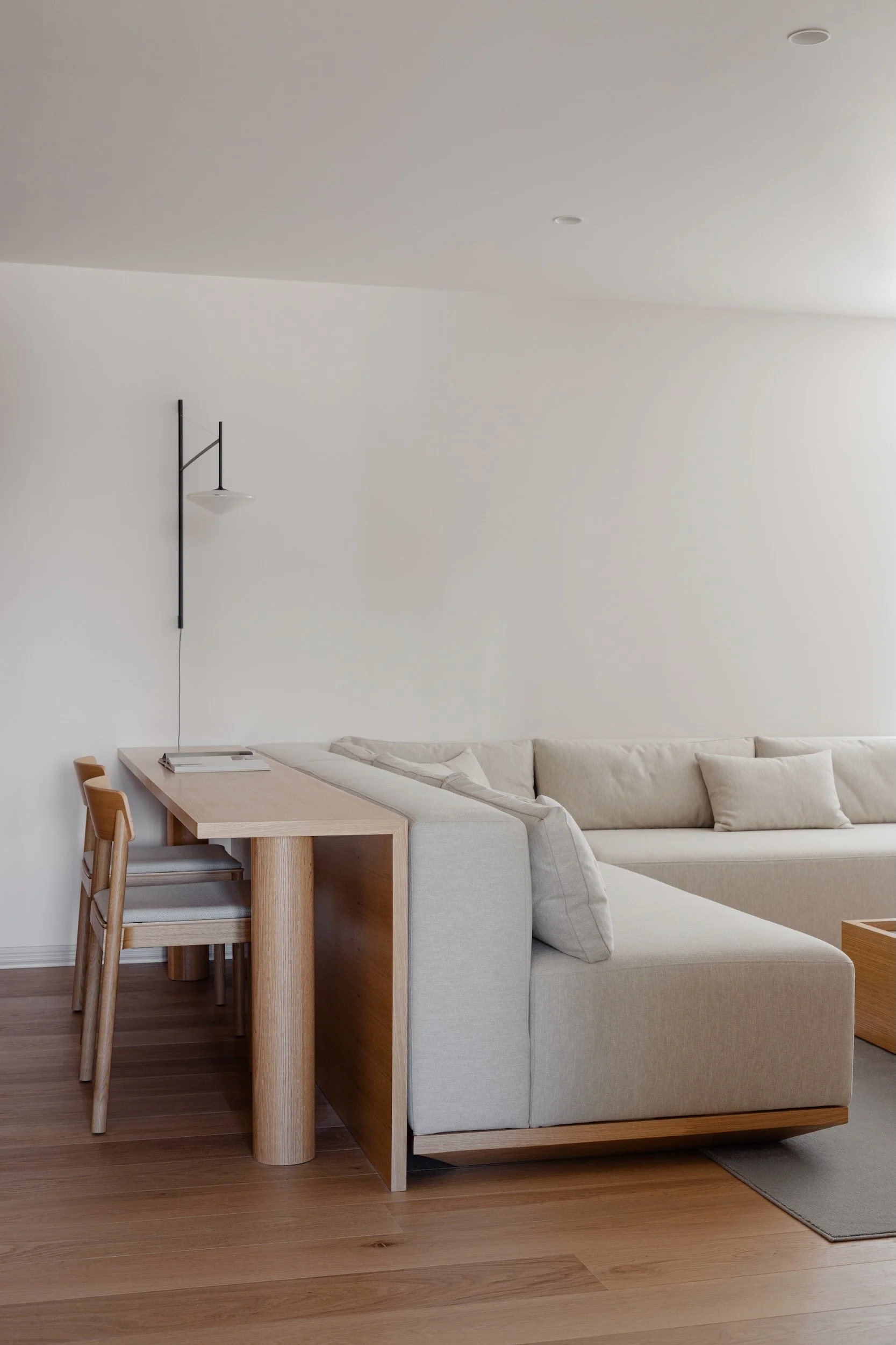 Lola Cwikowski Studio Cascais Residence project with custom Somma Carpintaria sofa in Lauritzon Aqua; custom oak console desk; &Tradition Betty TK2 chairs; Vibia Tempo sconce; CutCut Praia rug; Fenesteves engineered oak floor.