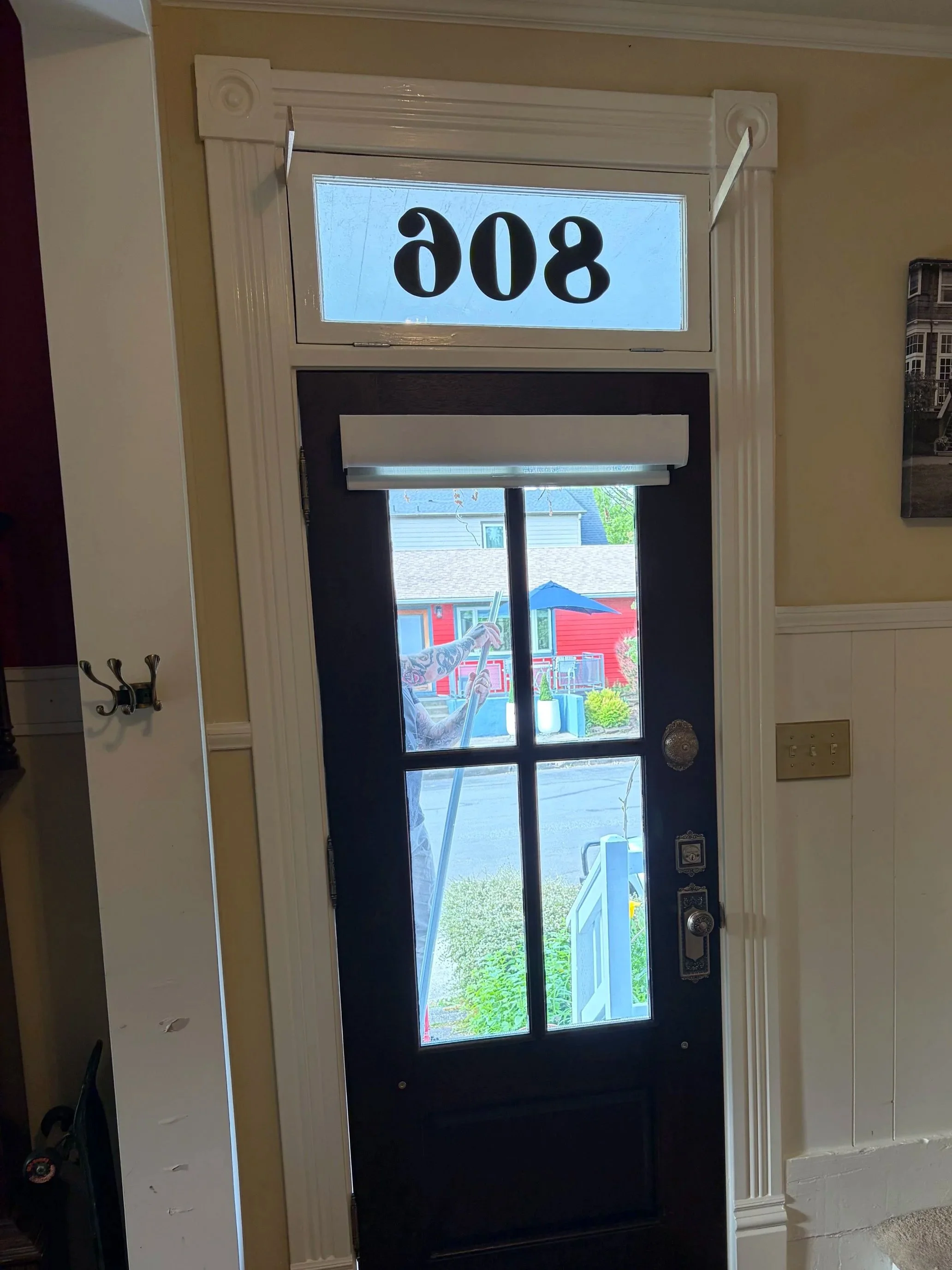 Restored historic entry door transom window prepared for new hardware installation in a Portland home, allowing the original operable transom to function again.