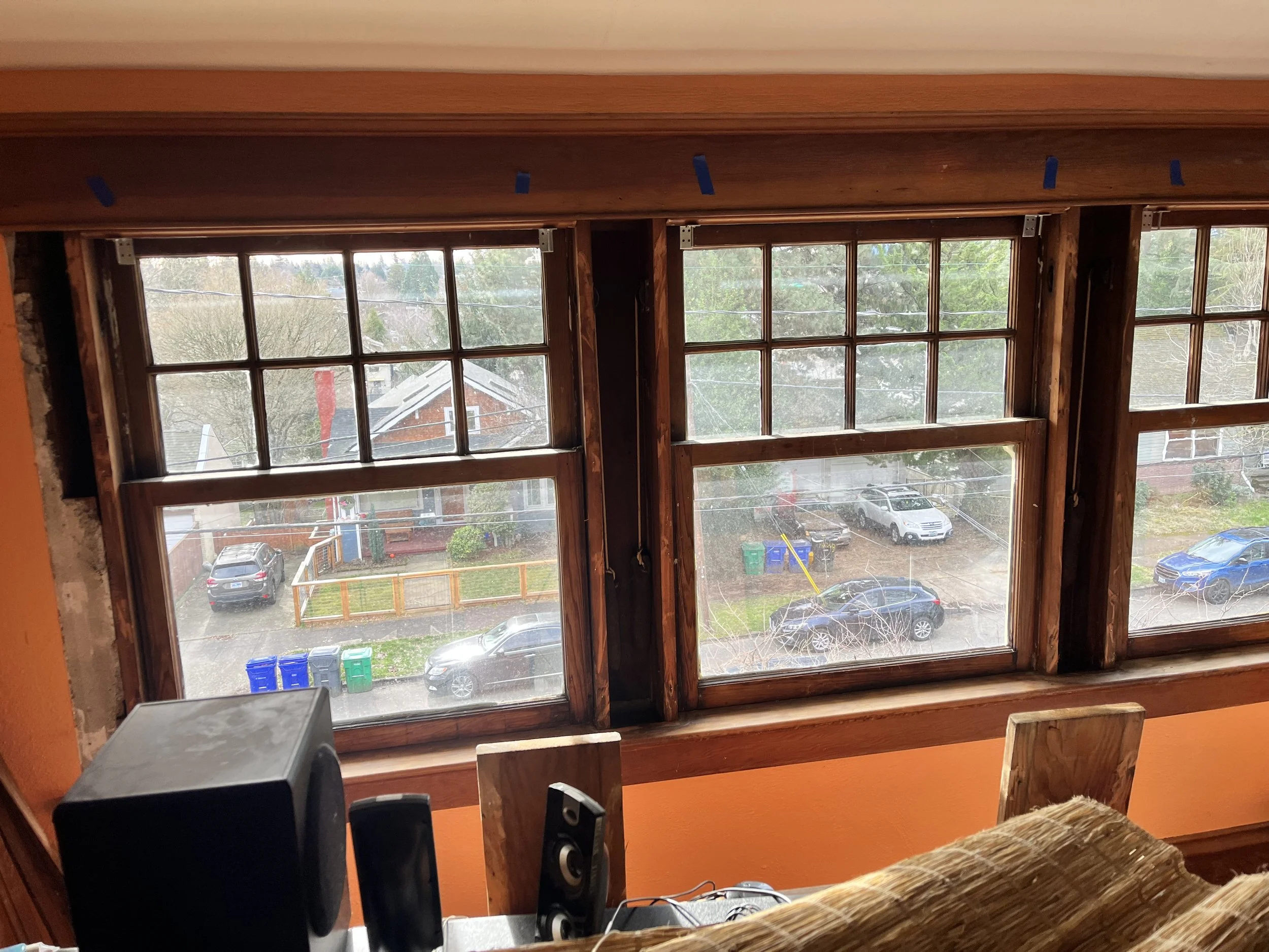 Century-old double-hung wood windows undergoing sash cord and weight system repair in SE Portland.