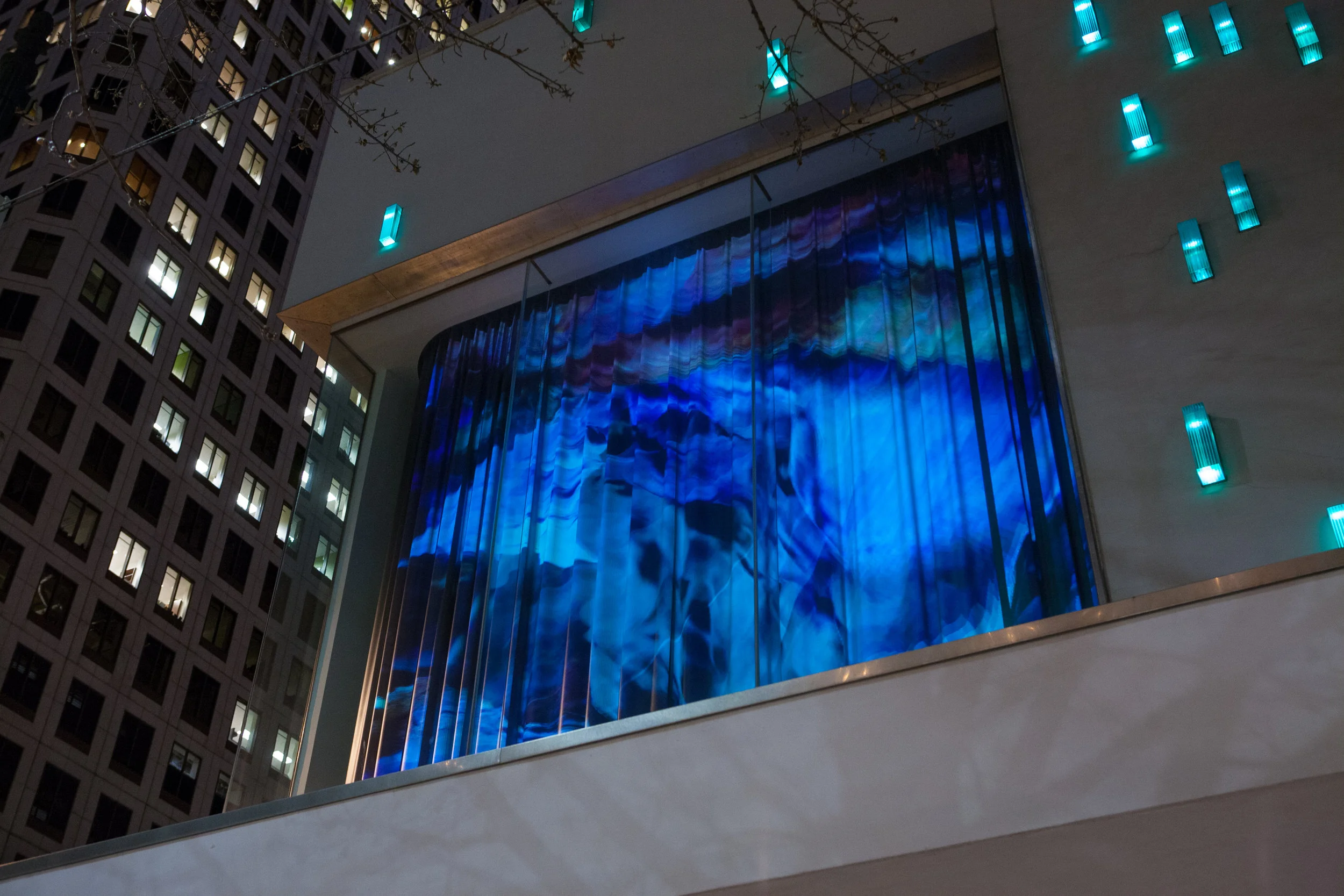 The building facade includes a speaker array that wraps the building facade allowing the soundtrack to be heard at street level.