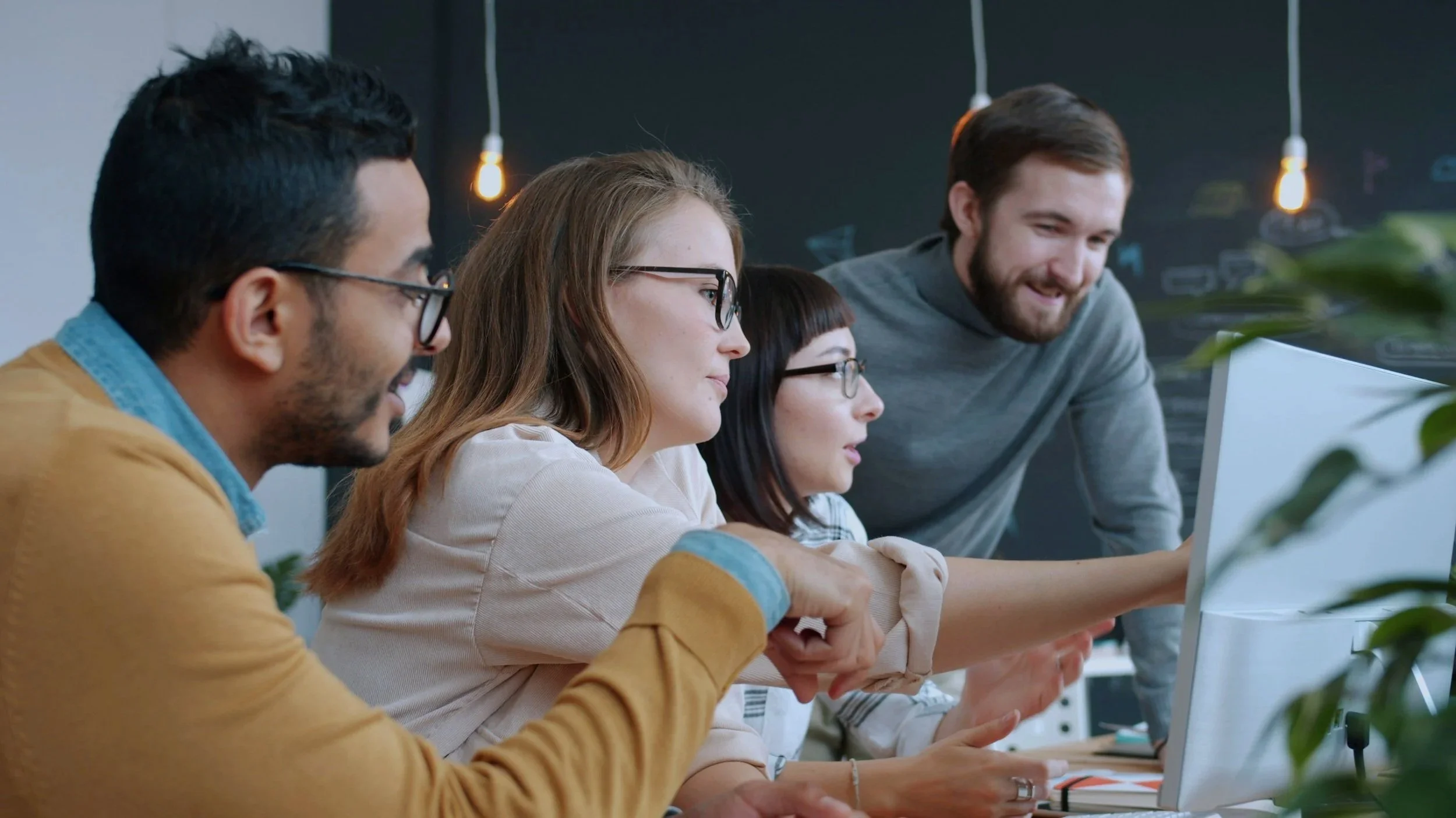 Team members in a group discussion, one gesturing while speaking
