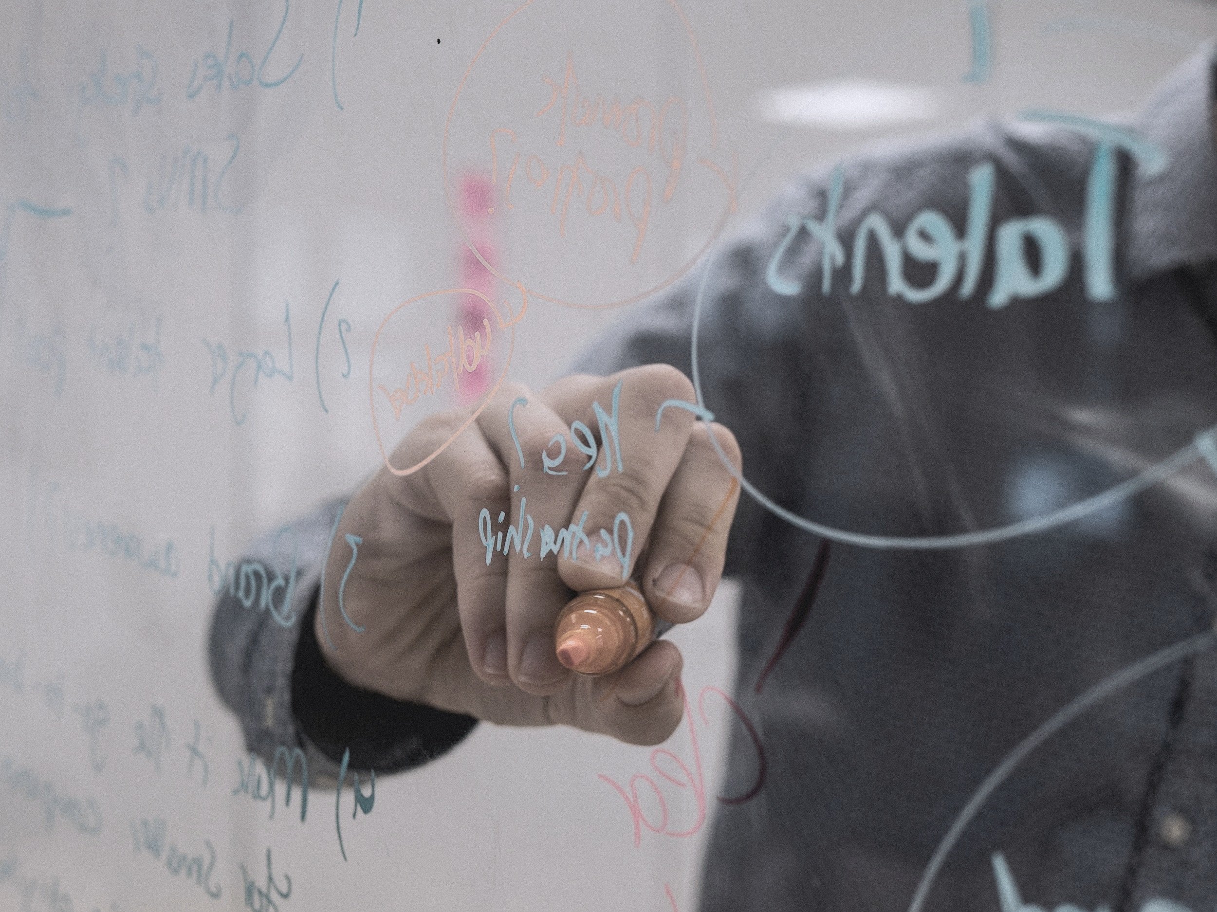 Image of man writing on a glass wall