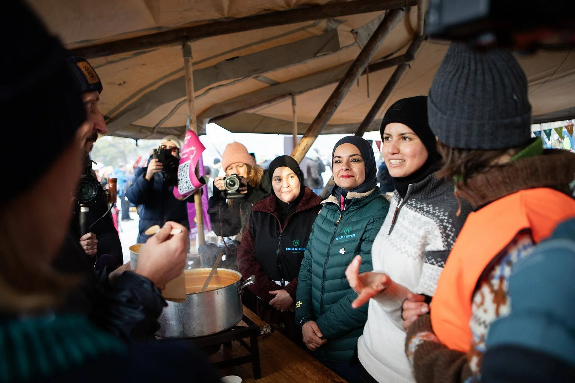 mennesker ute i et telt med lue og hijab.