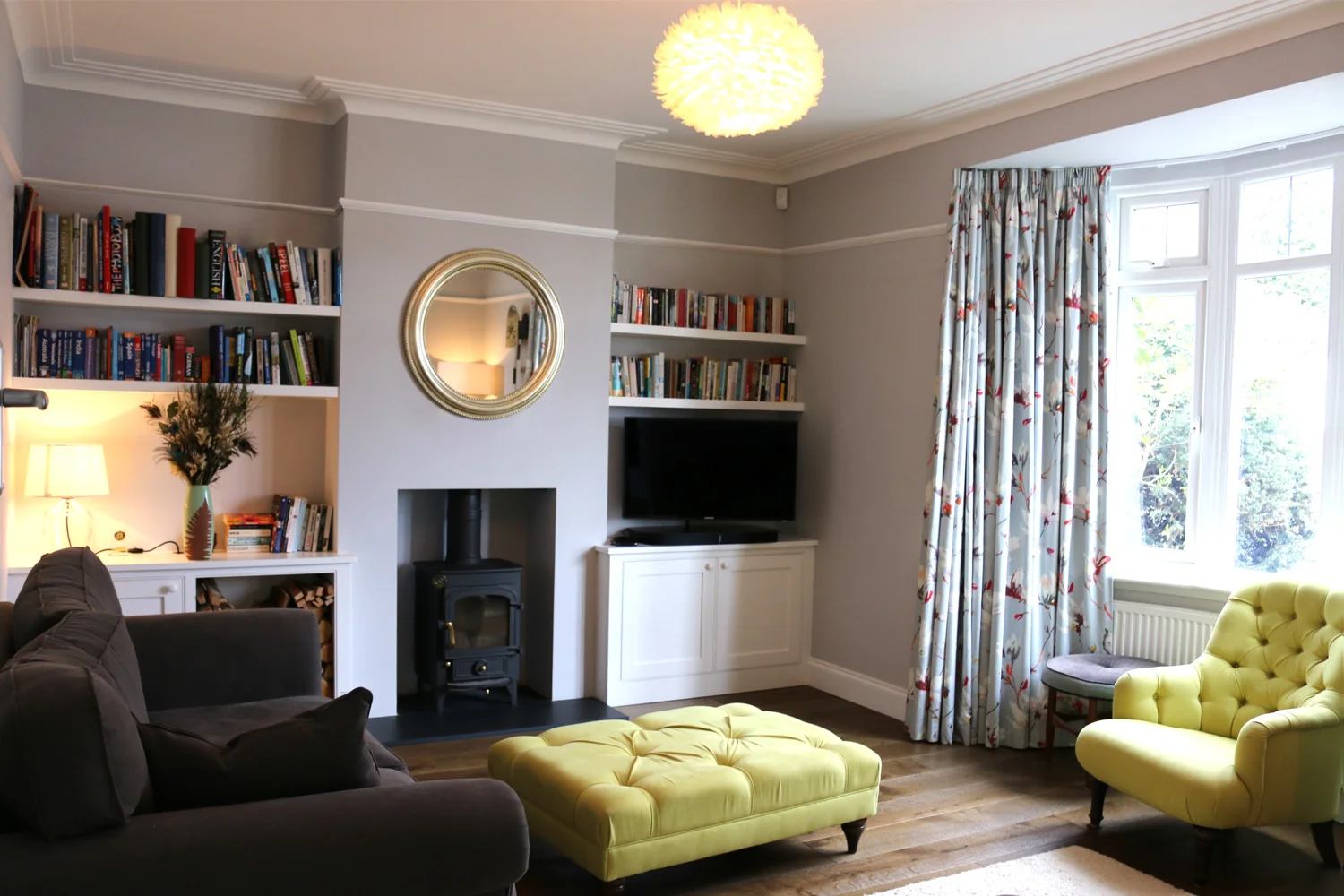 Neutral grey wall colour with contrasting zesty yellow upholstery at Thorpewood Avenue, London SE26