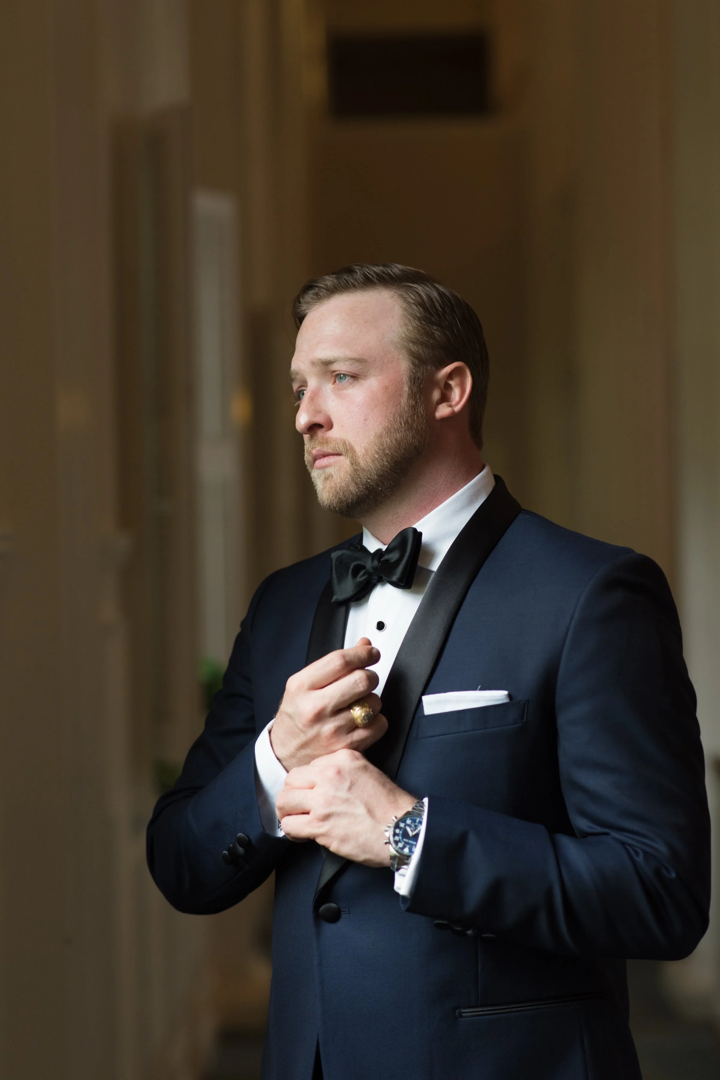 Groom getting ready looking out window