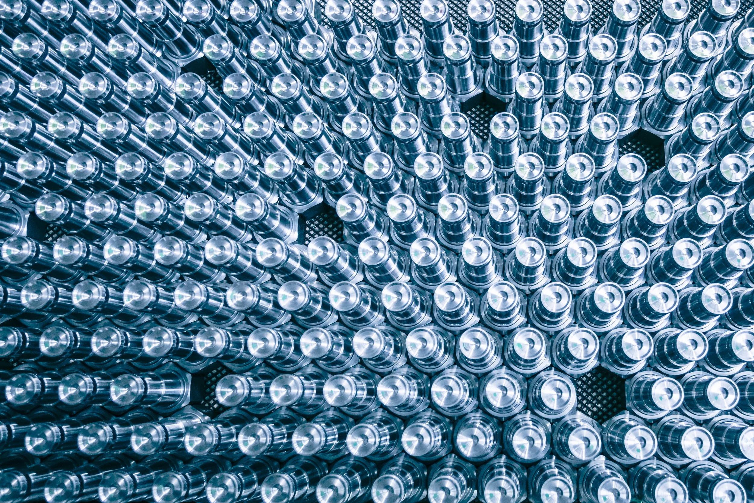 A large number of metallic aluminum cans stacked together in plastic crates.
