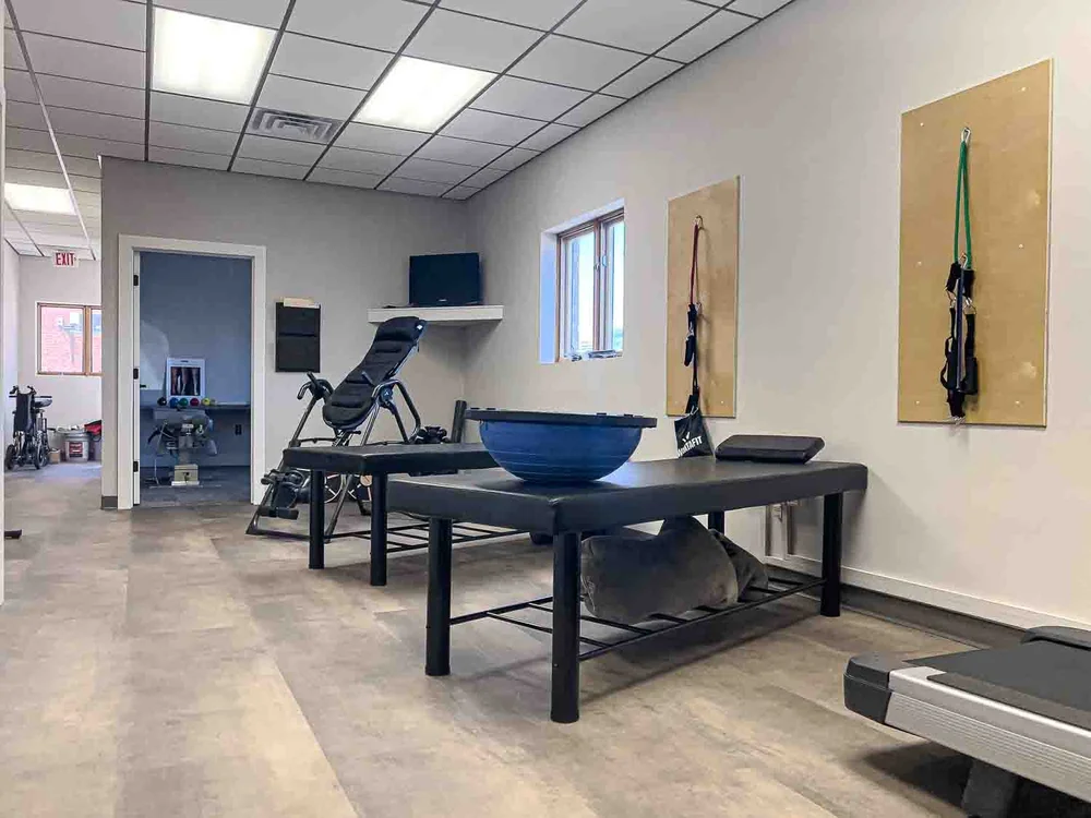 Rehab room at Borealis Wellness Clinic with treatment table, treadmill and exercise equipment