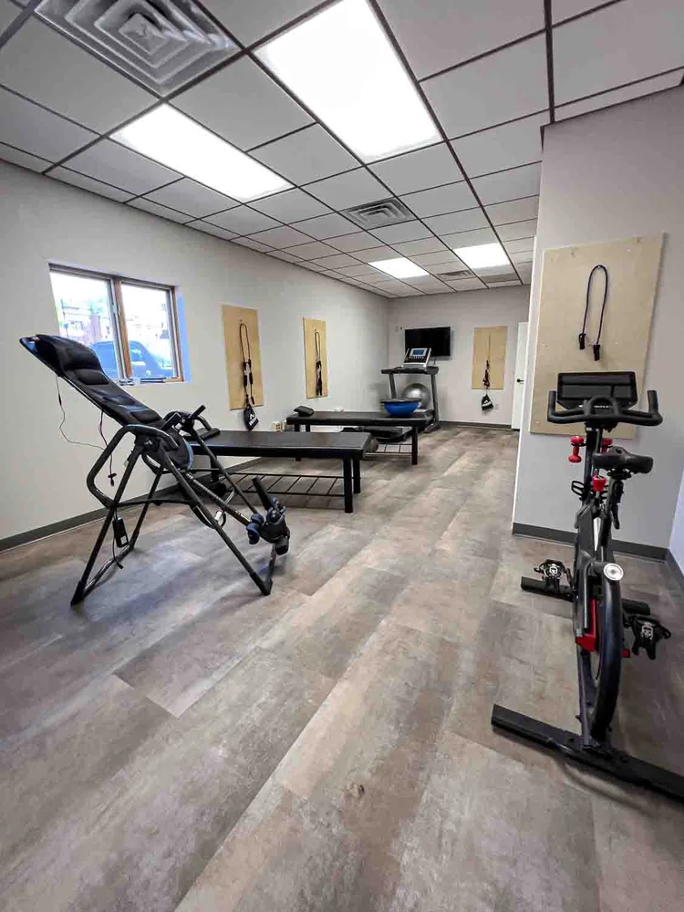 Rehab room with inversion table, stationary bike and therapy equipment