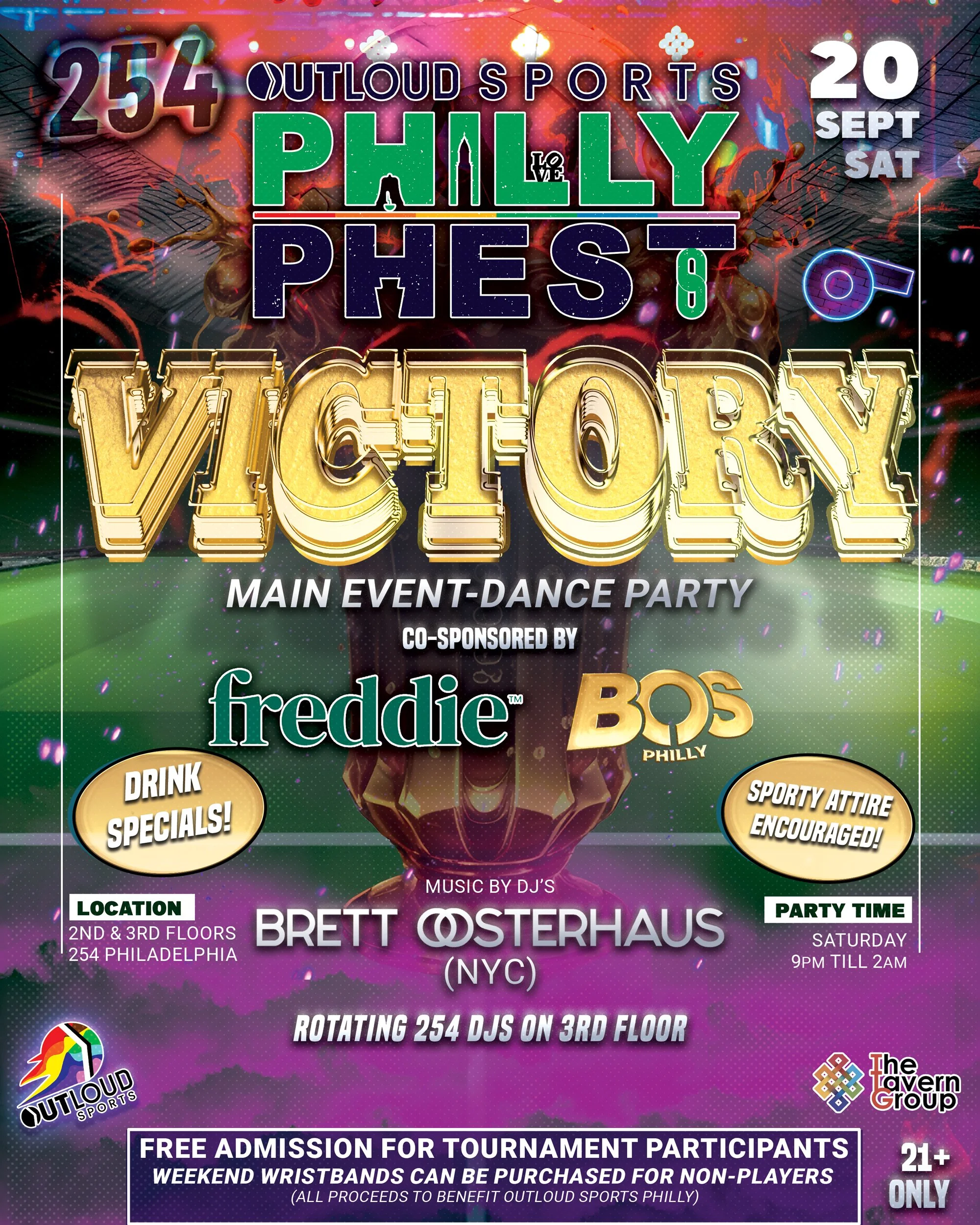 A large group of people smiling and posing for a photo at an outdoor event at night. There is a backdrop with logos, and the setting is decorated with greenery and lights.