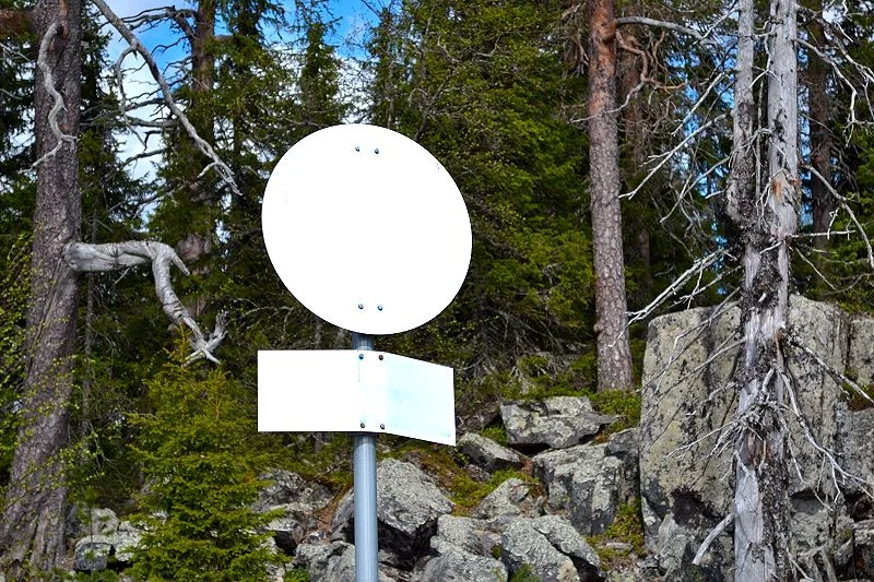 Tervetuloa Syötteen kansallispuistoon. Nämä rajakyltit ovat yleensä sinisiä, mutta tuuli lienee repinyt maalin irti.