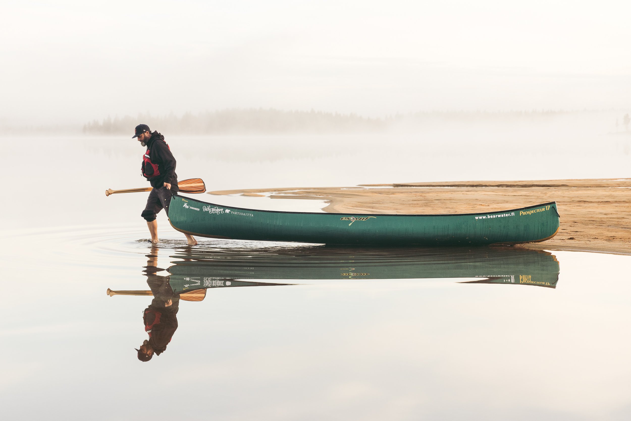Kanadalainen seikkailija Martin Trahan kiskoo kanoottia rannassa.