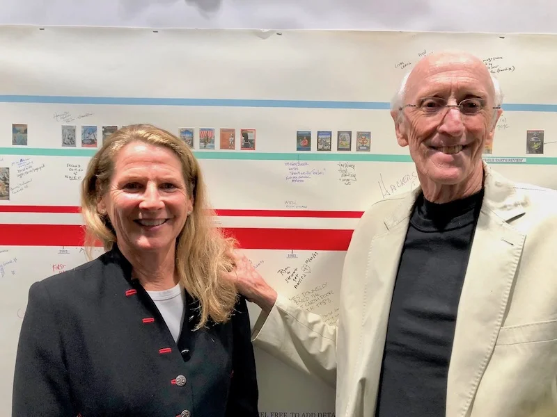 Organizers Ryan Phelan and Stewart Brand pose for one last photo in front of a 50-year timeline of the Whole Earth Catalog’s long history. Photo by Fabrice Florin .