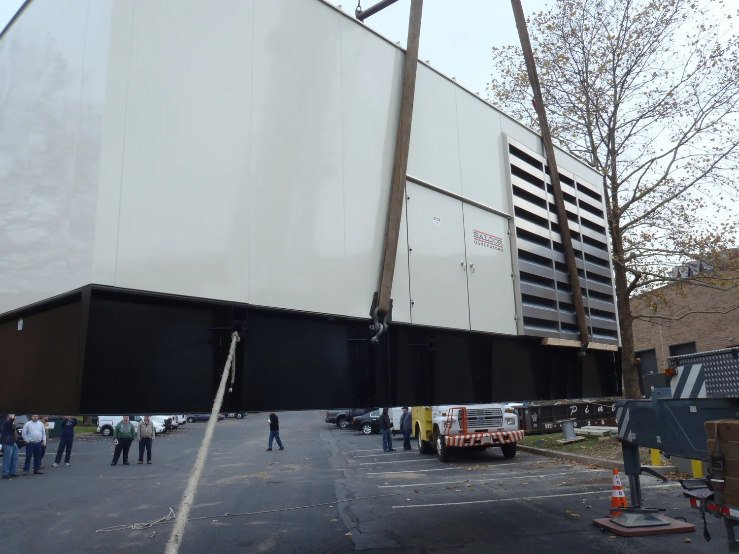 Large generator enclosure being positioned at an industrial property