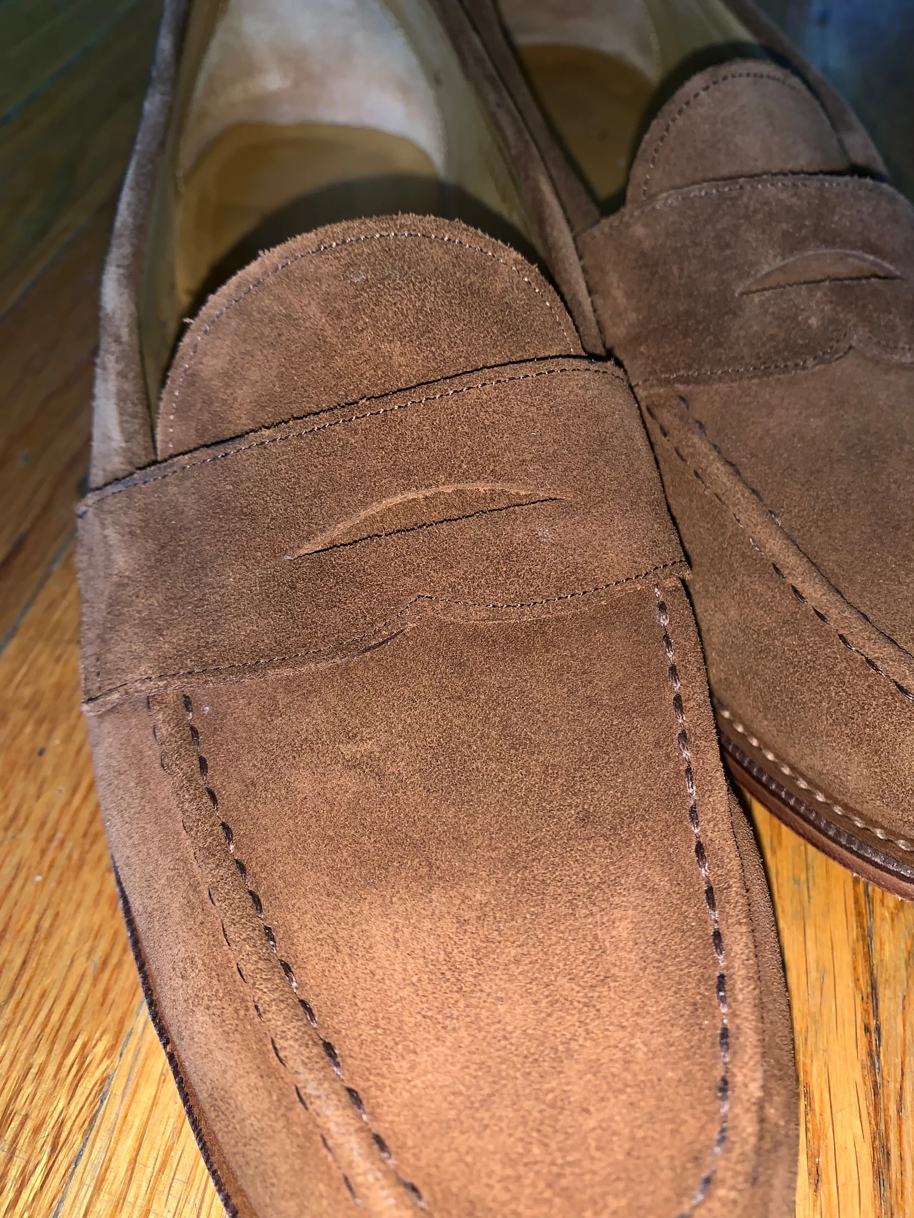 A close-up view of the snuff suede and circular penny loafer slot