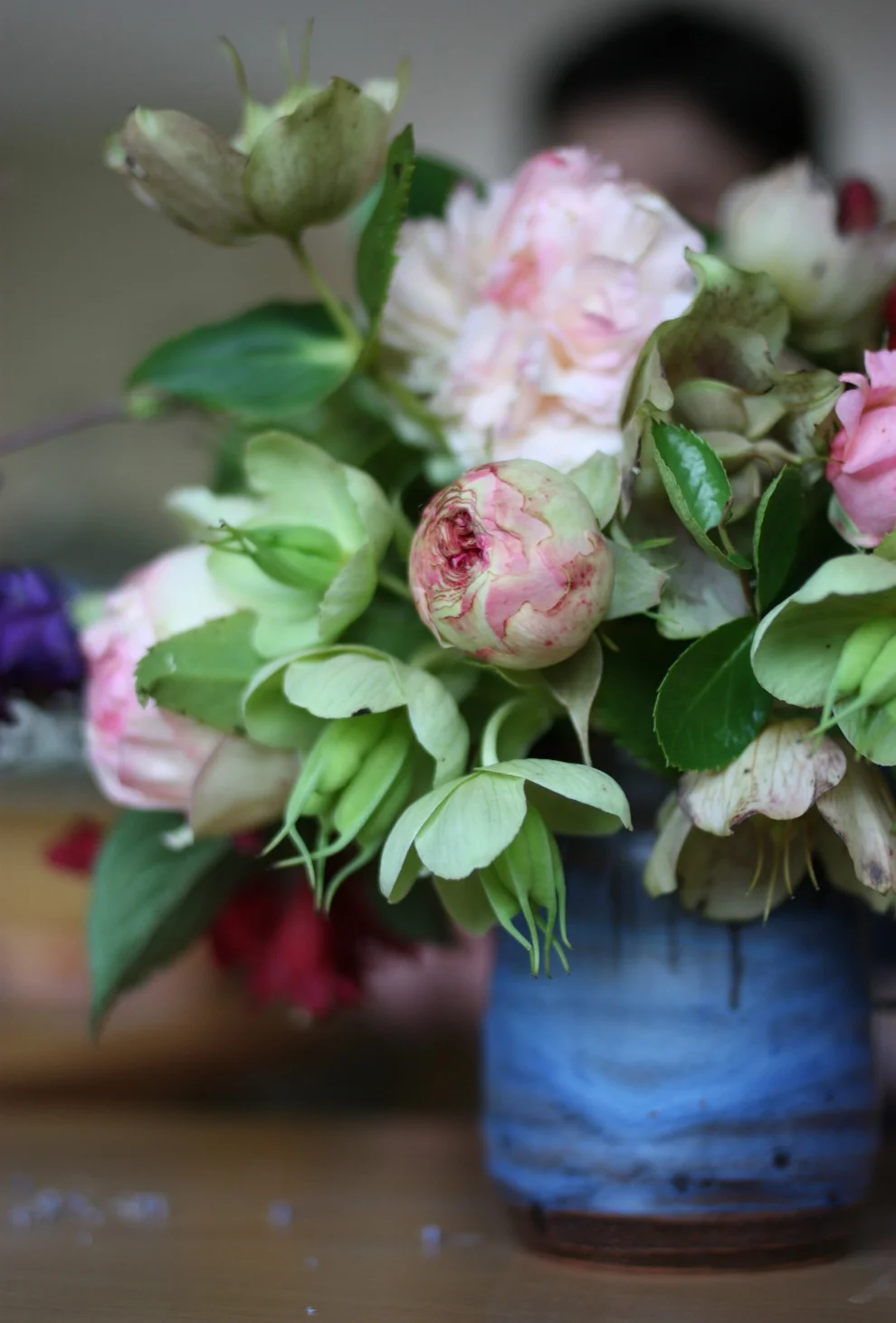 Roses and Hellebores from the garden in a blue vase