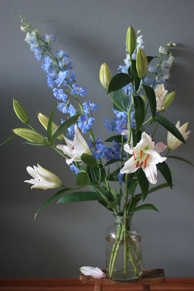 A tall bouquet of lilies and delphiniums and a floral give away
