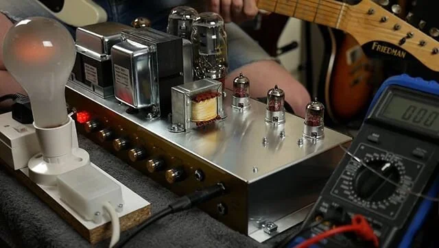 Testing for sound: a quick blast to ensure the newly built amplifier is passing signal and that all the controls work. 
The faintly glowing lightbulb is part of the testing equipment, designed to take the load should any wiring mistakes within the am