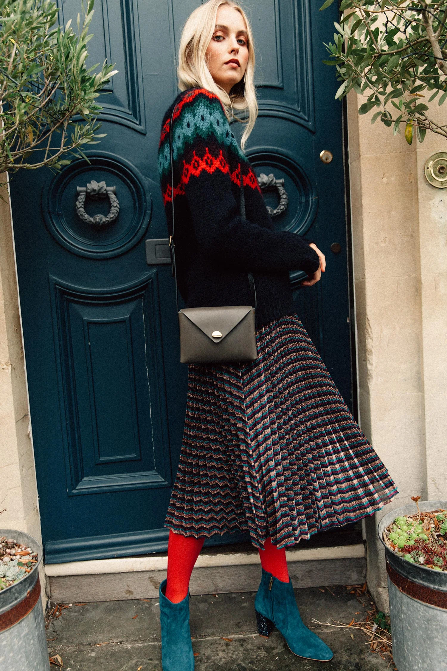 Fair Isle alpaca sweater in navy/multi, £165, Toast ; Metallic stripe pleated skirt, £159, Whistles ; Sarsgrove teal suede and glitter ankle boot, £180, DuoBoots ; Box bag in smoke, £255, Lucie Cast at East of Home; 60 denier red opaque tights, £5, Pretty Polly