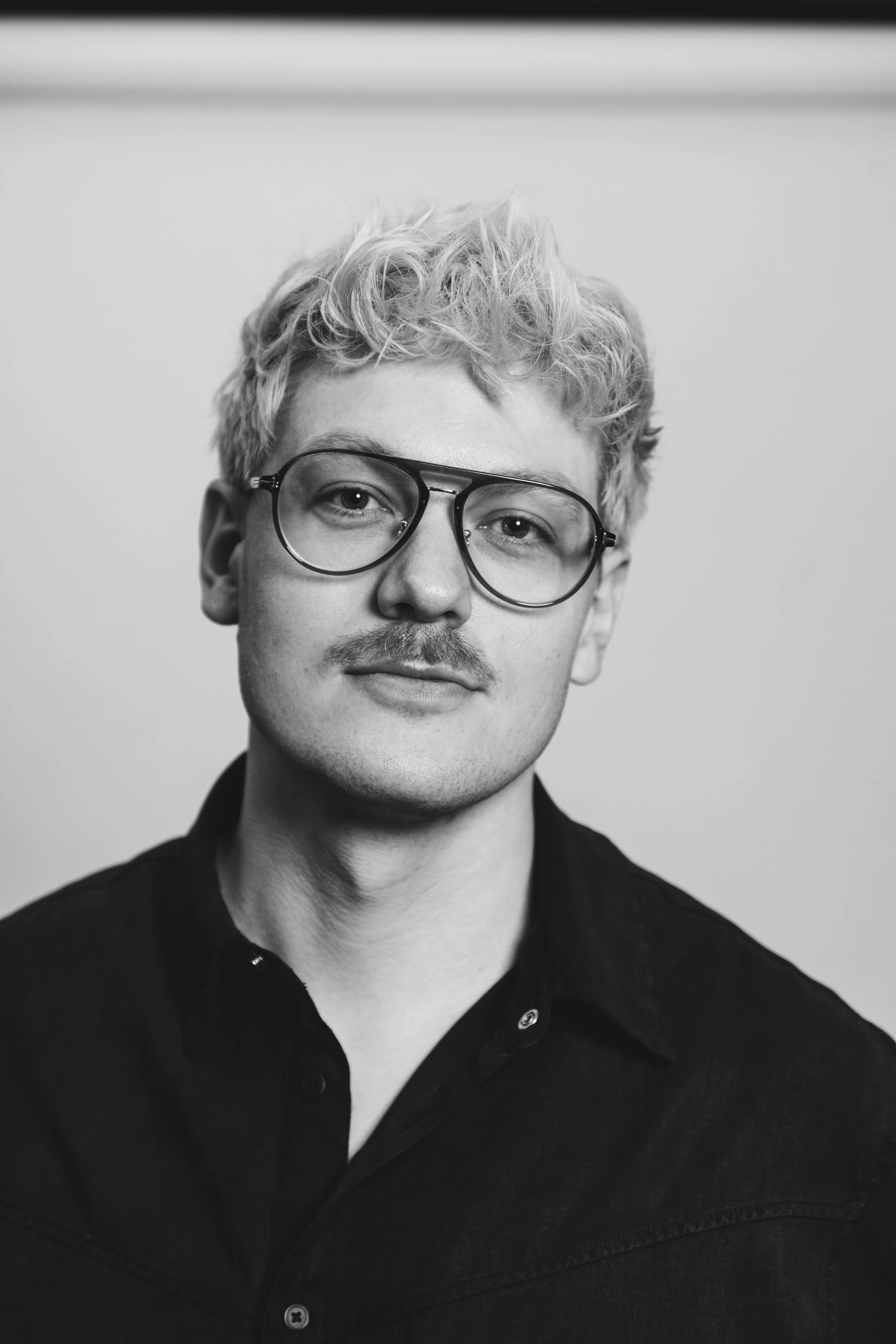 Black and white image of young man with glasses (leon krack)