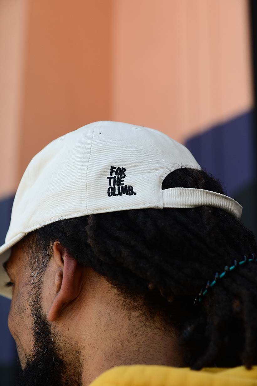 Backside of white hat with text For The Climb