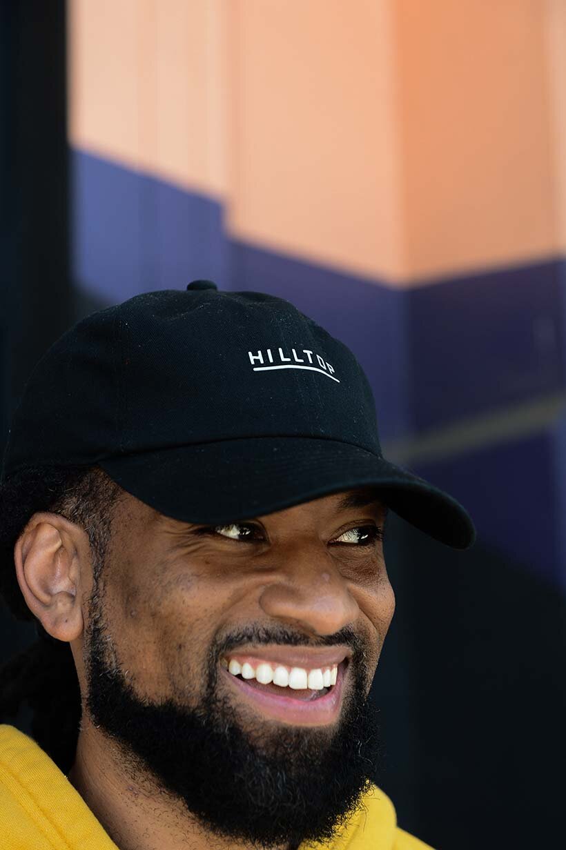 Black color hat worn by man that is smiling