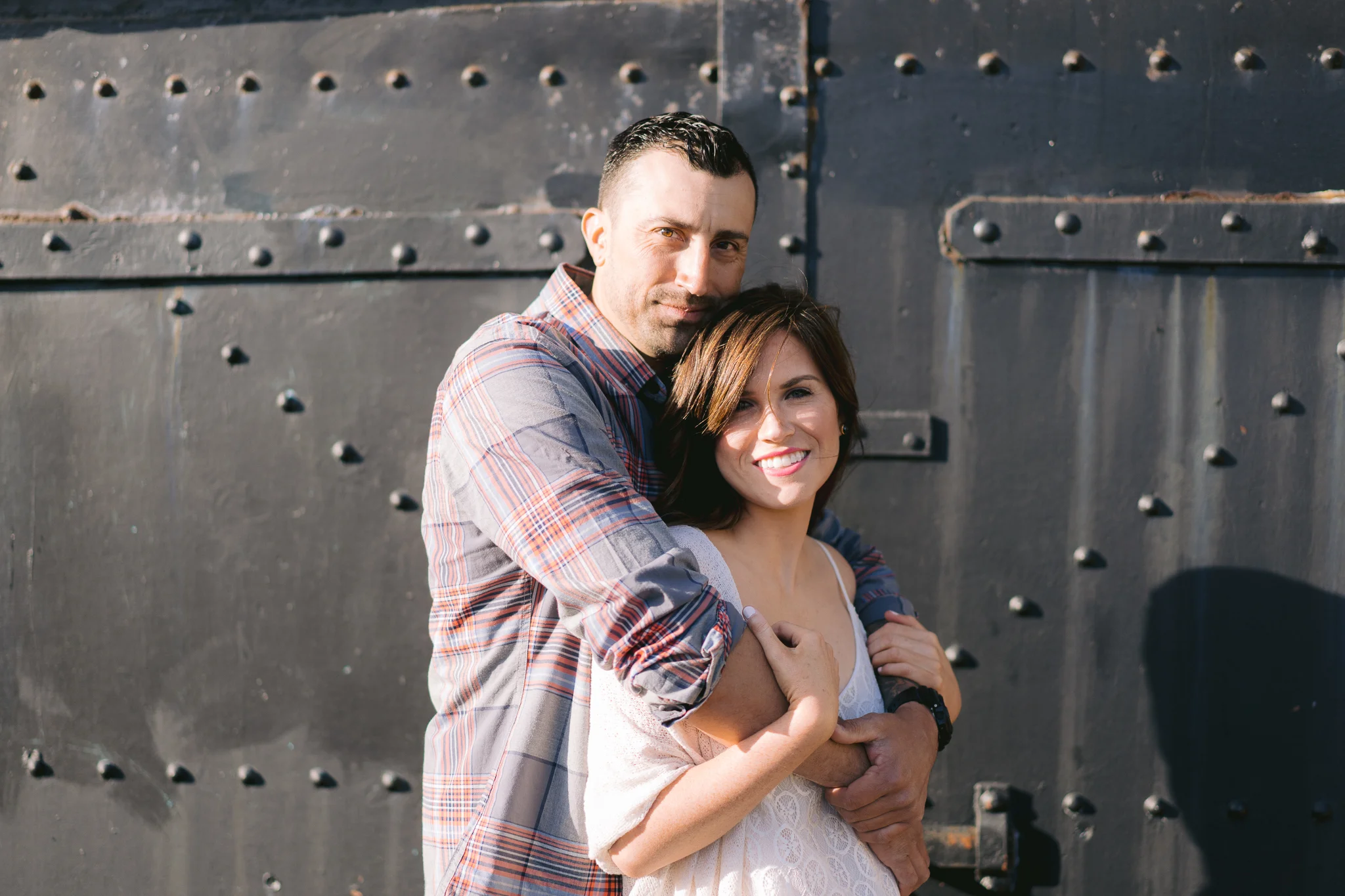 Romantic shot of couple with woman smiling during Engagement shoot in front of Battery Chamberlin.