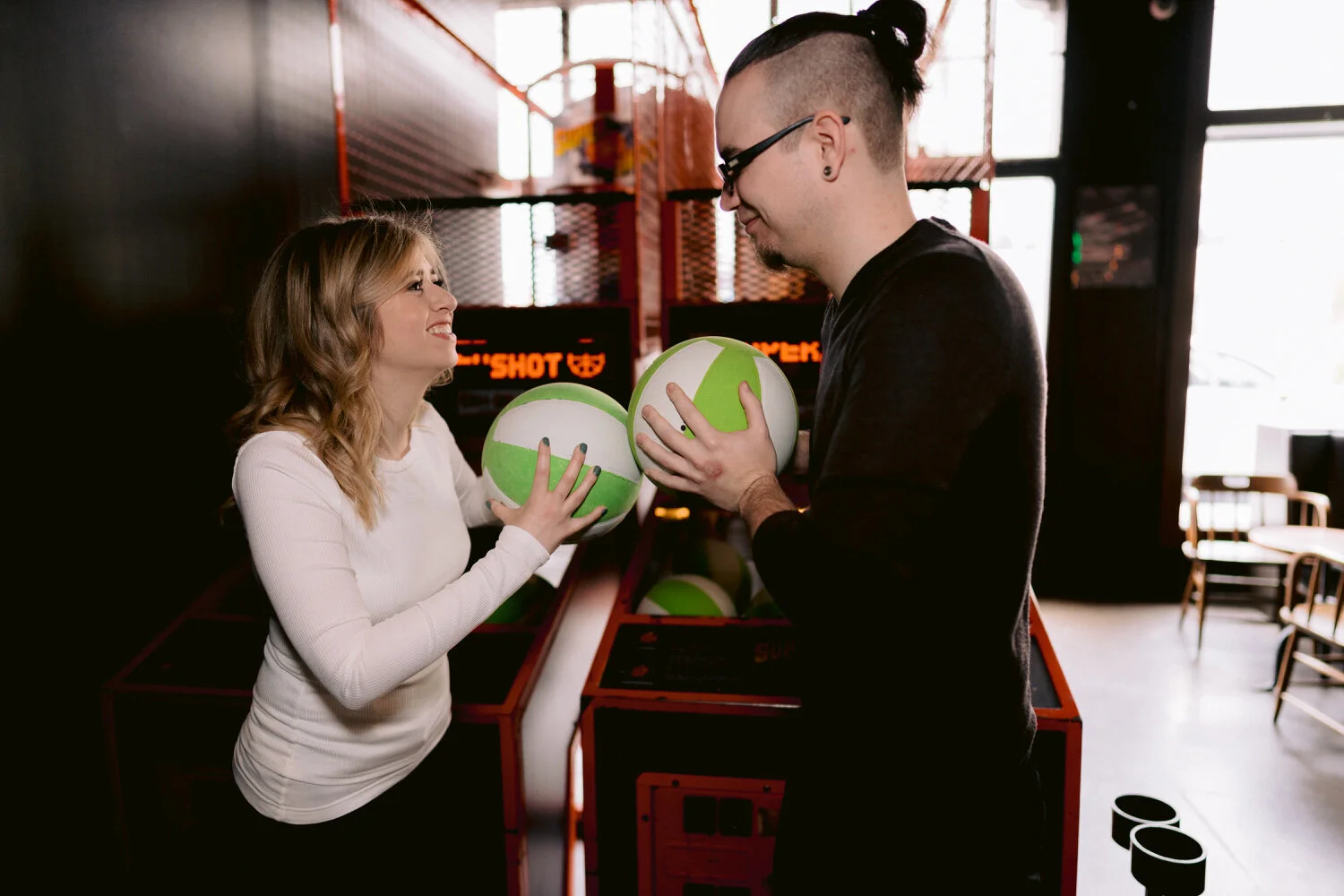 fun engagement photo of couple playing arcade basketball together at Coin-Op SF