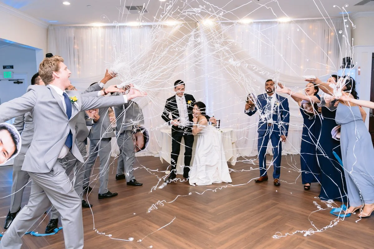 Bridal party covering bride and groom with silly string at San Ramon Waters wedding