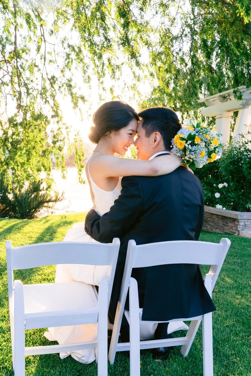 Sunset photo of bride and groom snuggling on ceremony chairs at their San Ramon Waters wedding