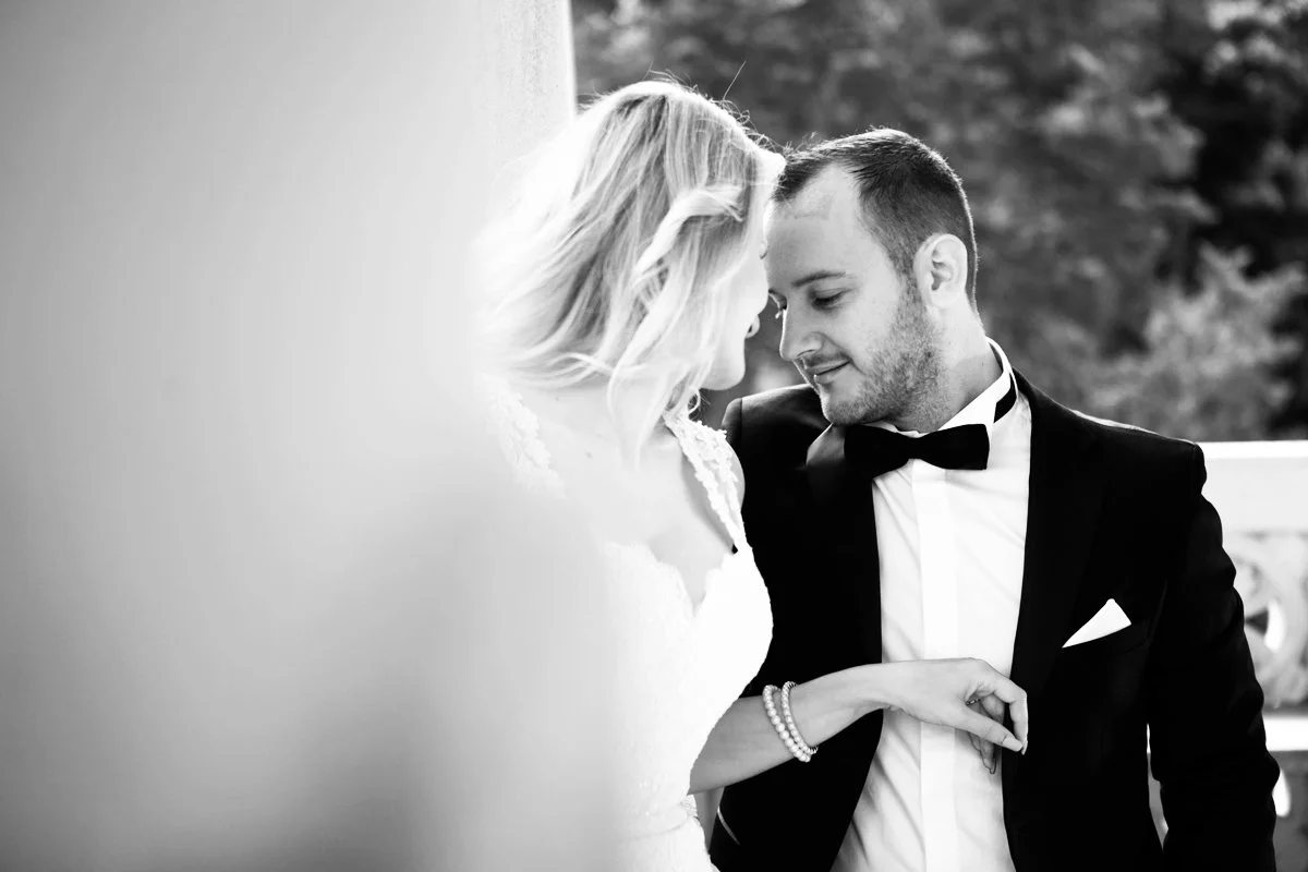 Bride and groom in formal attire embracing, black and white photo.