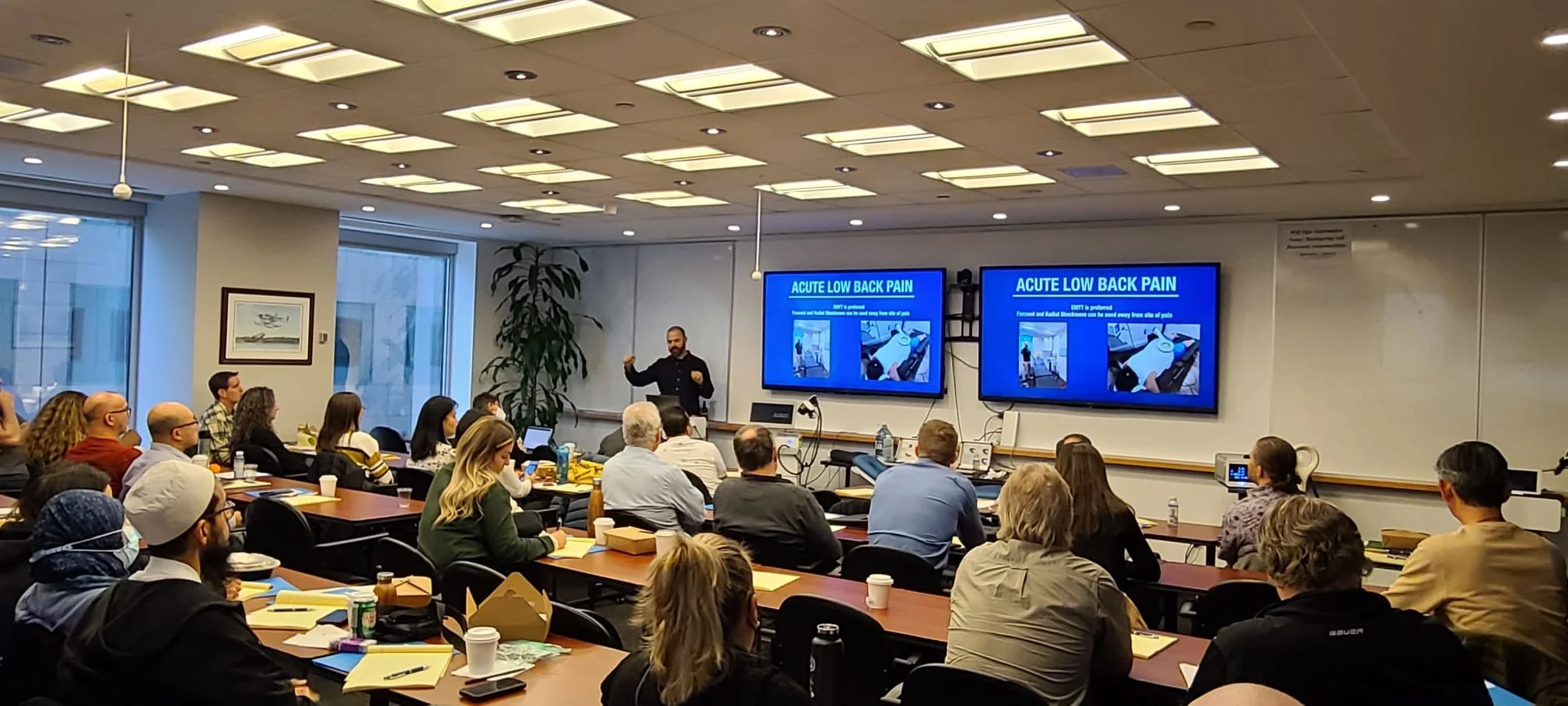 Dr. Nick Tsaggarelis presenting an educational session on neuromusculoskeletal care to healthcare professionals