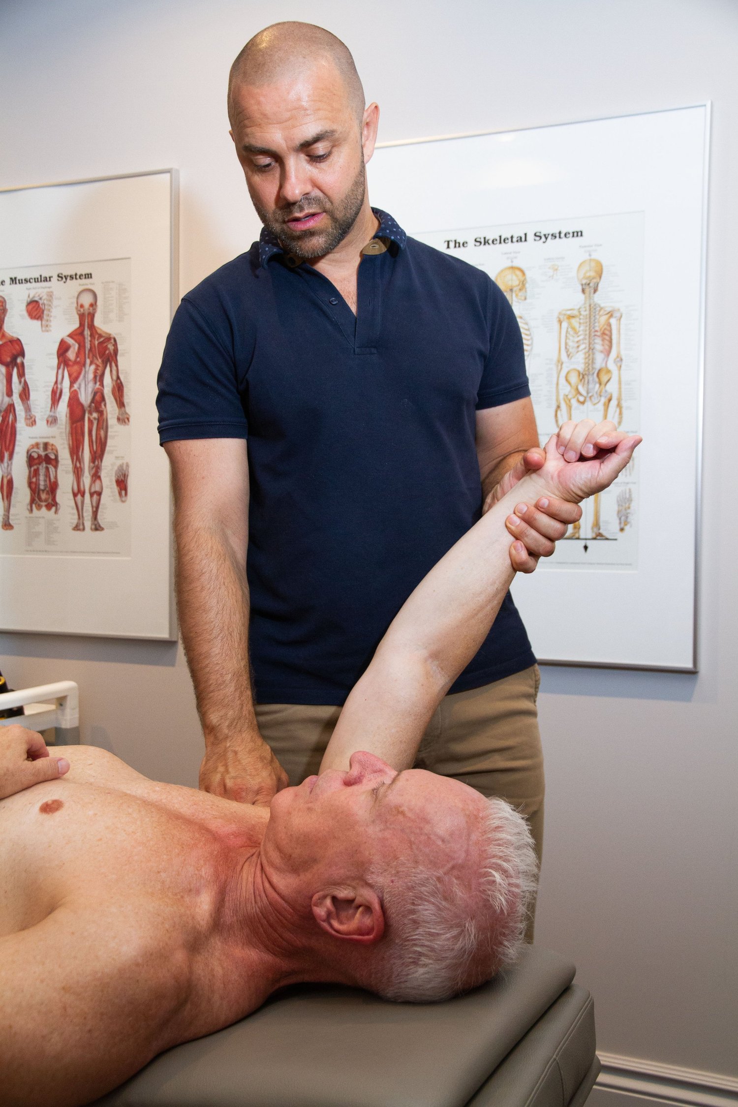 Dr. Nick performing gentle shoulder capsule mobilization to assess and support frozen shoulder recovery.